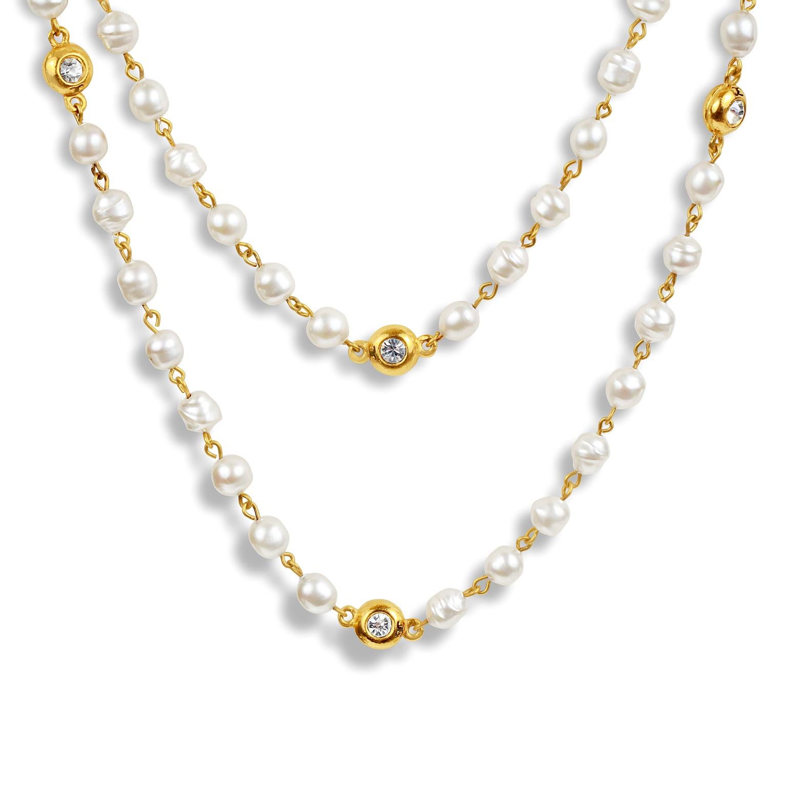 This authentic Chanel Pearl and Gold Extra Long Necklace is in excellent vintage condition from the early 1980’s.  Faux pearls are joined together with gold tone connectors.  Gold beads with crystal centers are stationed throughout.  Extra long
