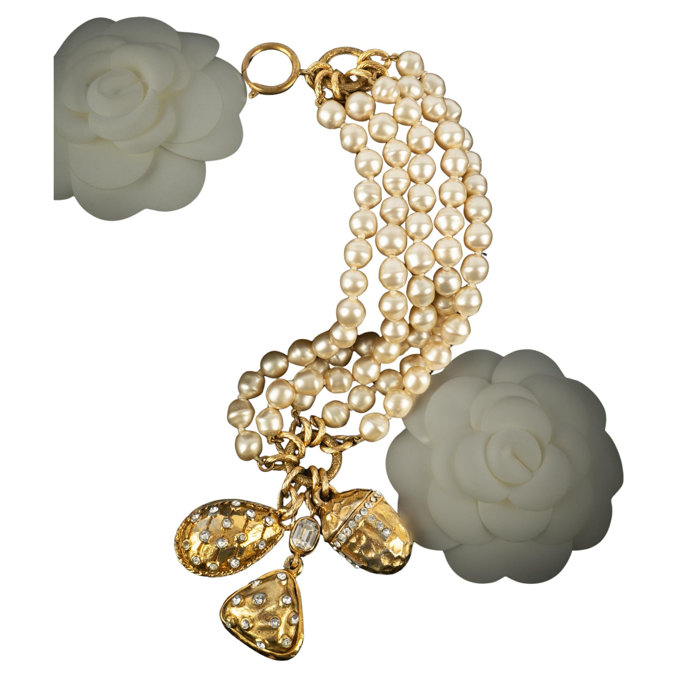 CHANEL - (Fabriqué en France) Bracelet fantaisie en perles avec breloques en métal doré et strass. Bijoux des années 1985.

Condit :
Très bon état.

Dimensions :
Longueur : 19 cm

SKU:BRAB16