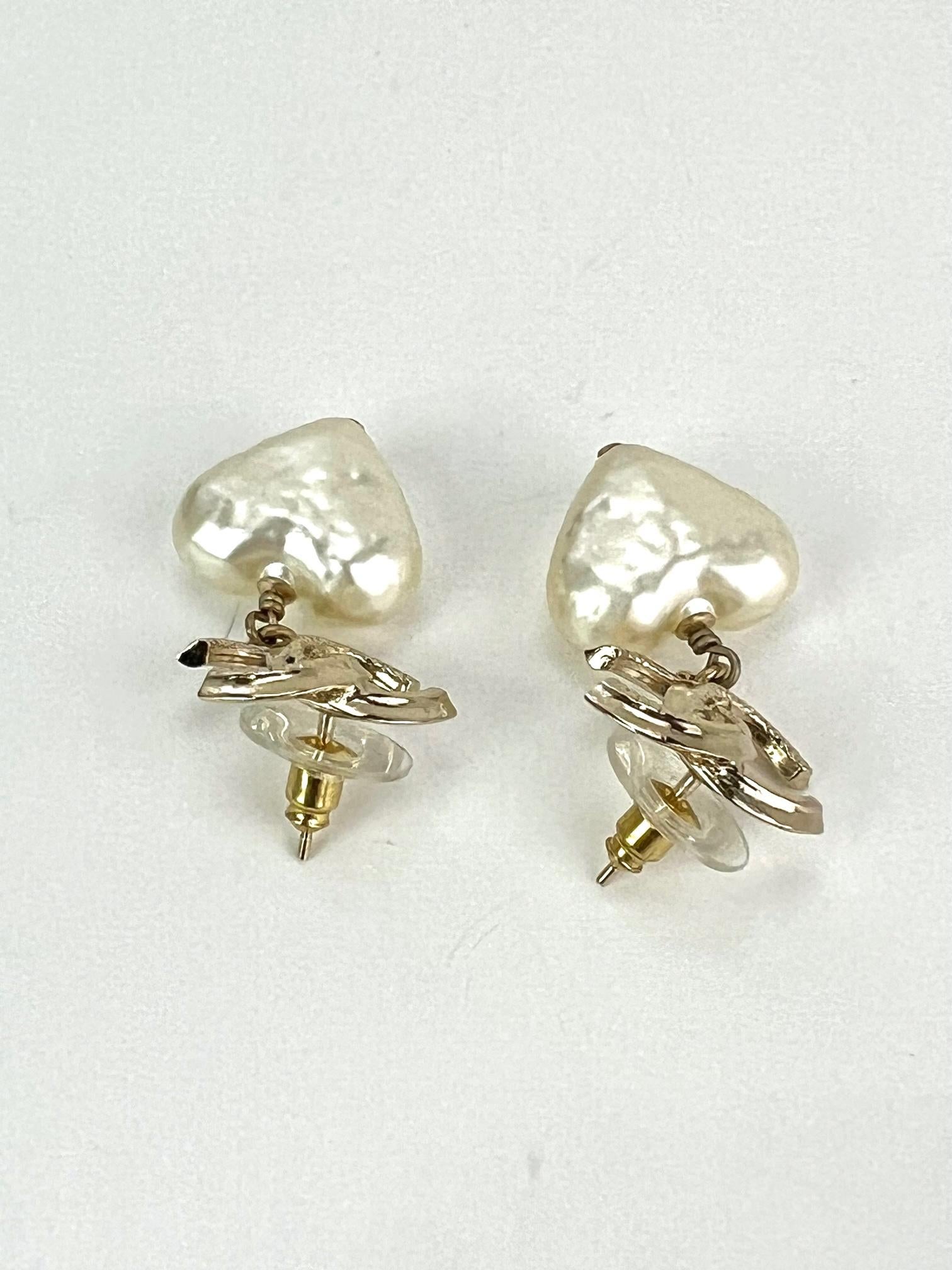 Pre-Owned 100% Authentic
CHANEL Pearl CC Heart Drop Earrings in Gold
RATING: A...excellent, near mint, only slight 
signs of wear
MATERIAL:  pearl hearts, metal
MEASUREMENTS: H 1.75'' x W .75''
BACKS: has plastic ring on backs for easier