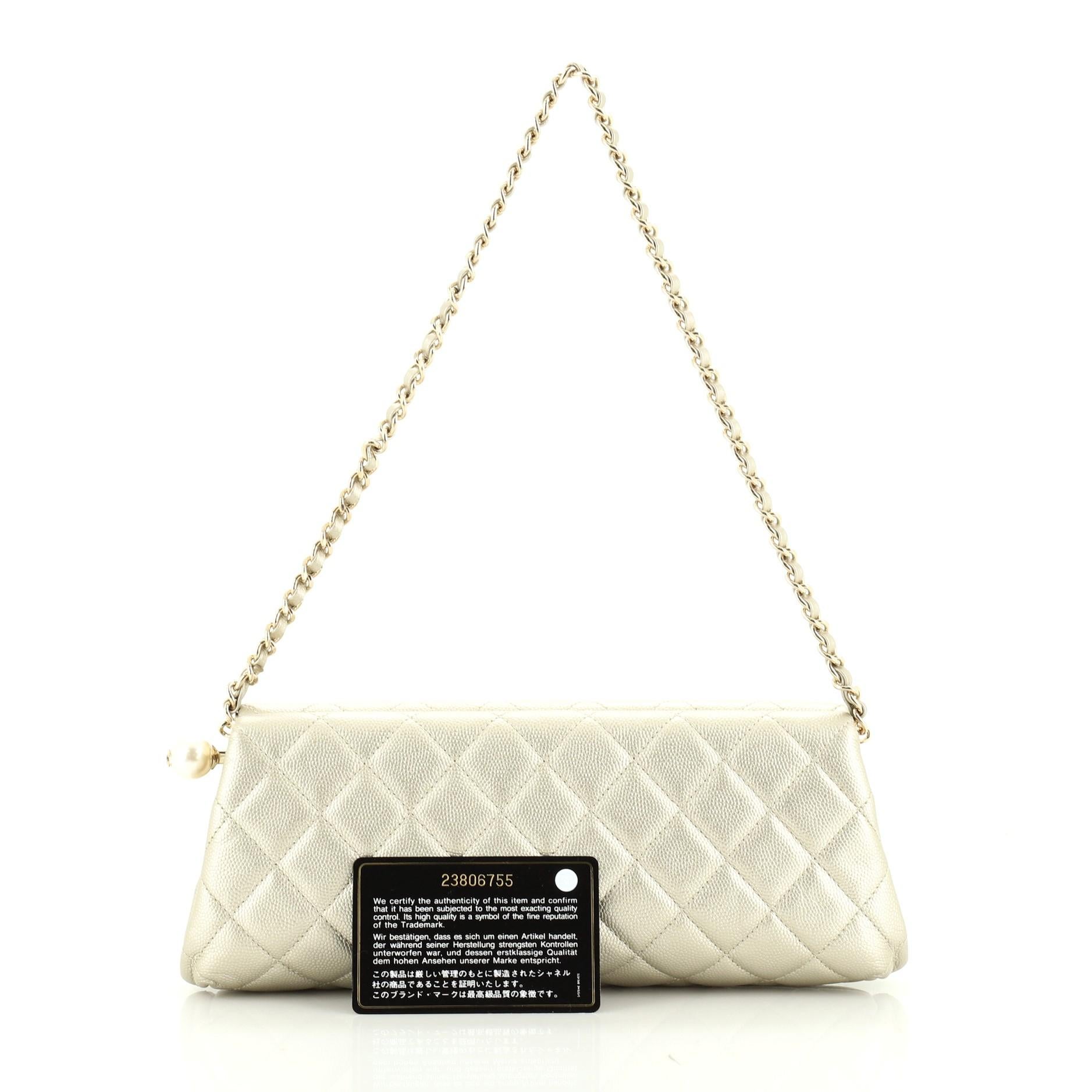 This Chanel Pearl Chain Clutch Quilted Caviar, crafted from gold leather, features chain link strap and gold tone hardware. Its closure opens to a gold satin interior. Hologram sticker reads: 23806755. 

Condition: Excellent. Minor wear on base