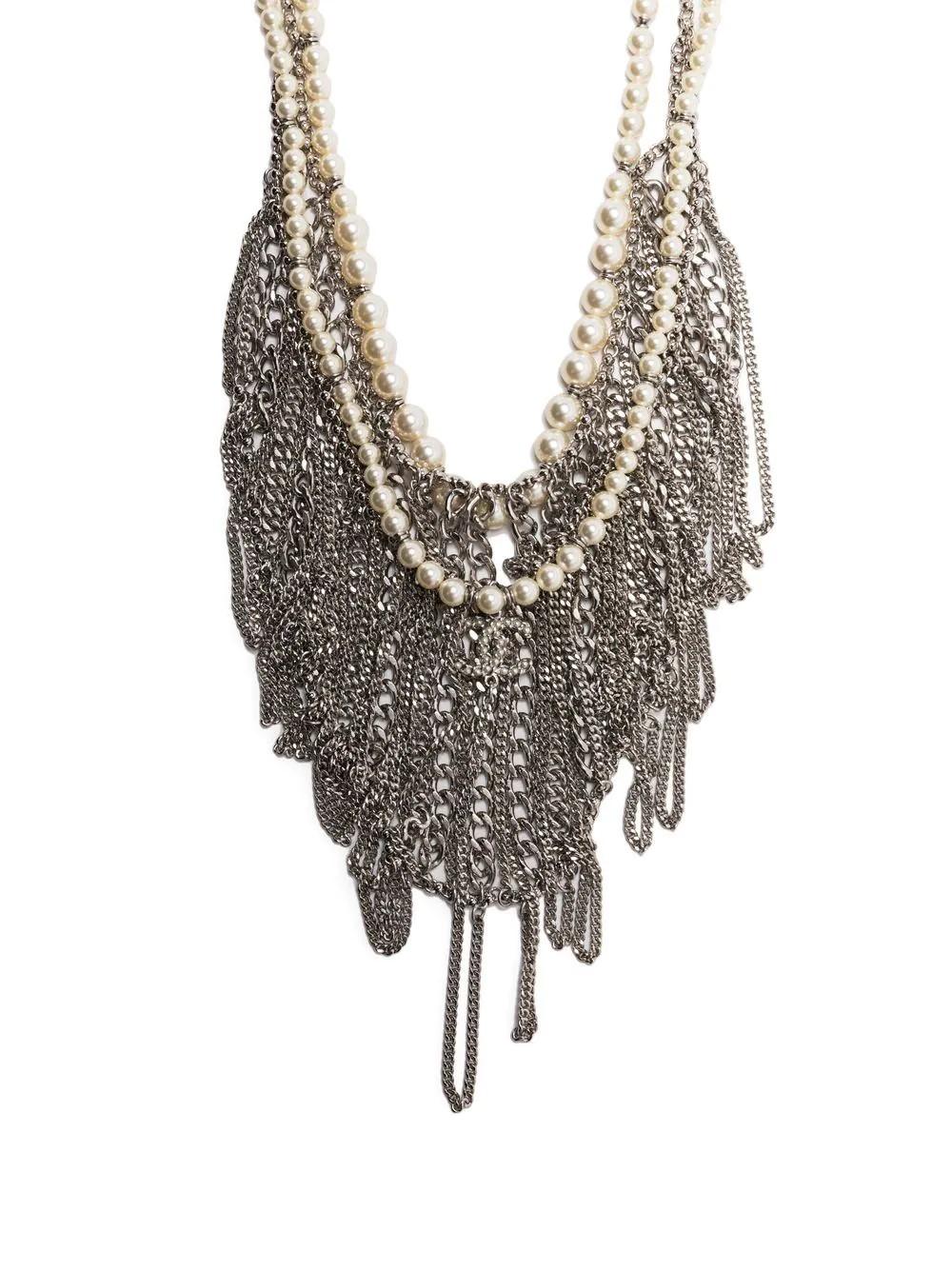 In excellent condition, with a Chanel pouch, this stunning statement necklace is a great find. Coming from the 2015 collection, this necklace has a double-layered silver chain and faux pearl embellishment. The iconic double CC can also be seen
