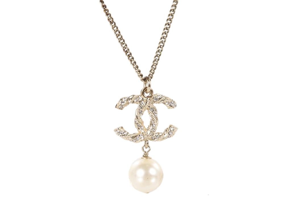 What a beautiful pendant by Chanel with a pearl drop and crystal embellished CC on the front. A lovely addition to any outfit you wear and truly very chic. A pre-owned necklace in excellent condition. The chain has tarnished in some places.

This