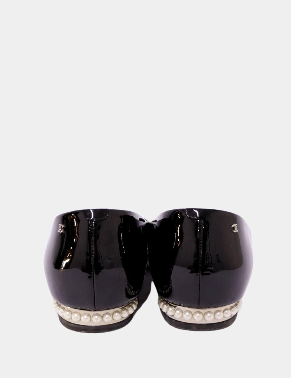 Timeless elegance meets everyday comfort with these chic Chanel black patent leather ballet flats. Featuring the signature cap toe and low block heel adorned with a row of iconic Chanel pearls, these flats are a true reflection of the house’s