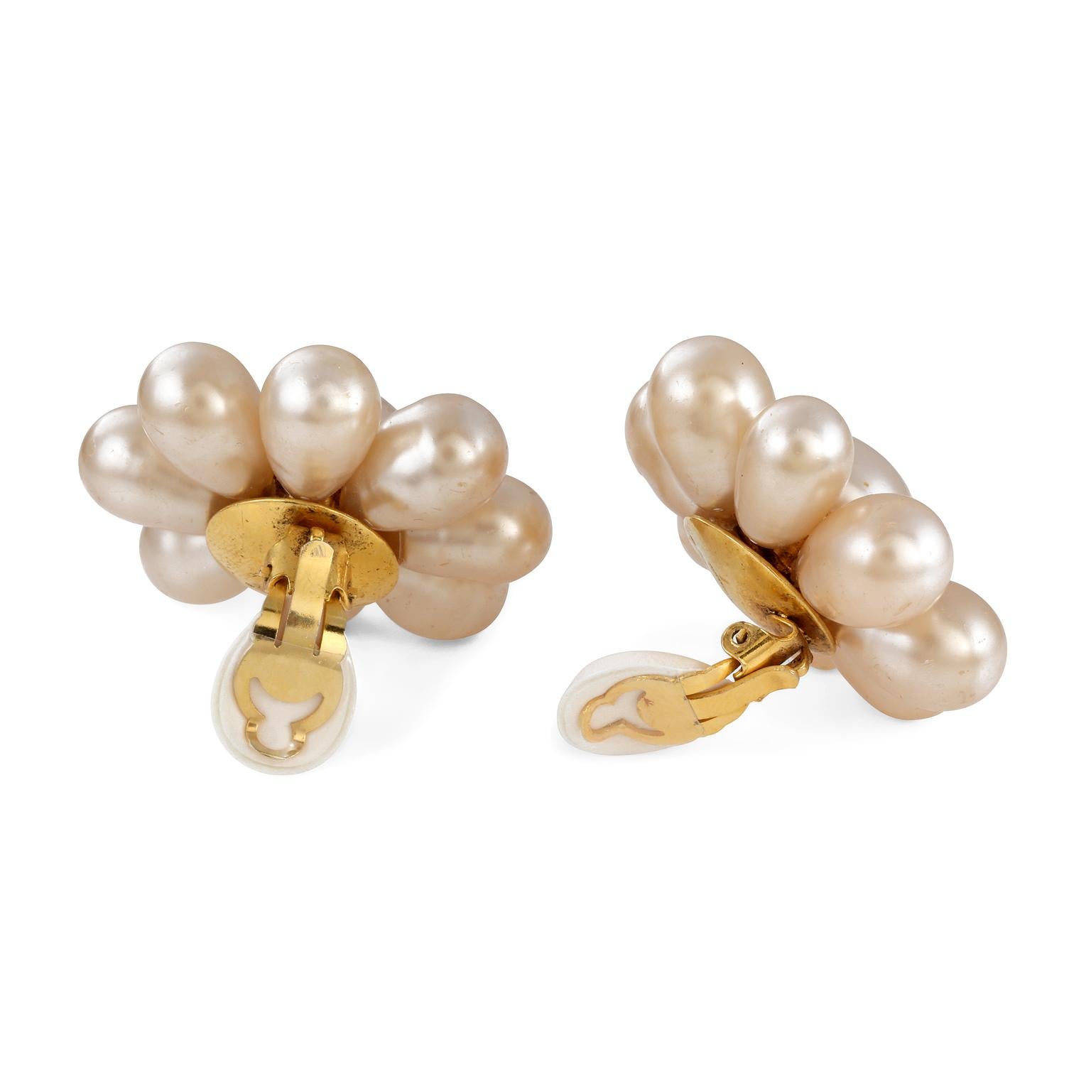 Ces authentiques boucles d'oreilles en perles de Chanel sont en très bon état et datent des années 1970 et du début des années 1980.  Les fausses perles créent une fleur simple avec une fermeture à clip.   Fabriqué en France.  Pochette ou boîte