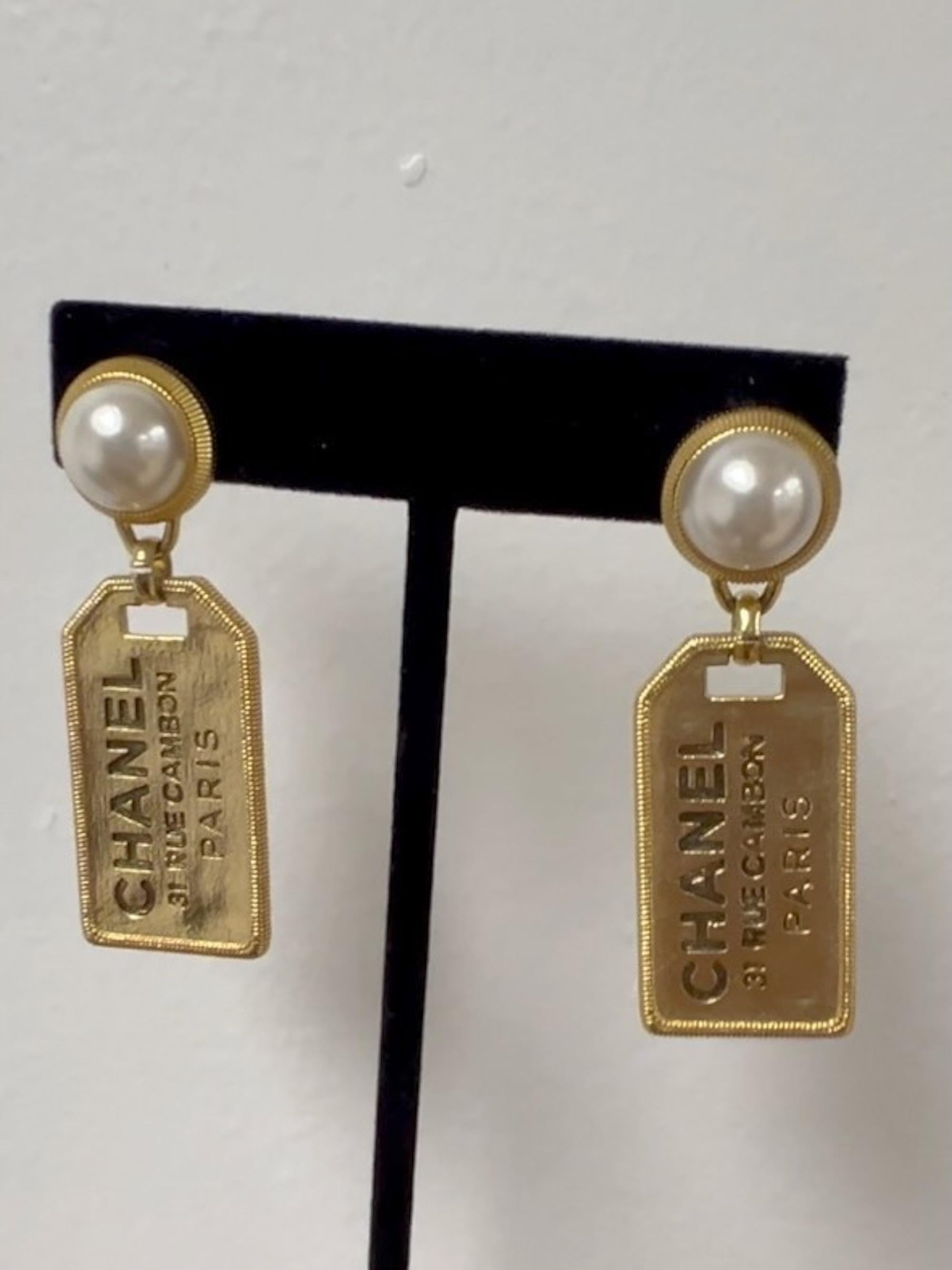 Introducing Chanel mini tag earrings in gold tone metal with faux pearls. The tags are engraved with the 31 Rue Cambon address, which is the flagship location of Chanel in Paris.

100% Authentic

Marks: Chanel logo 2020
Clasp Style: clip ons
Year: