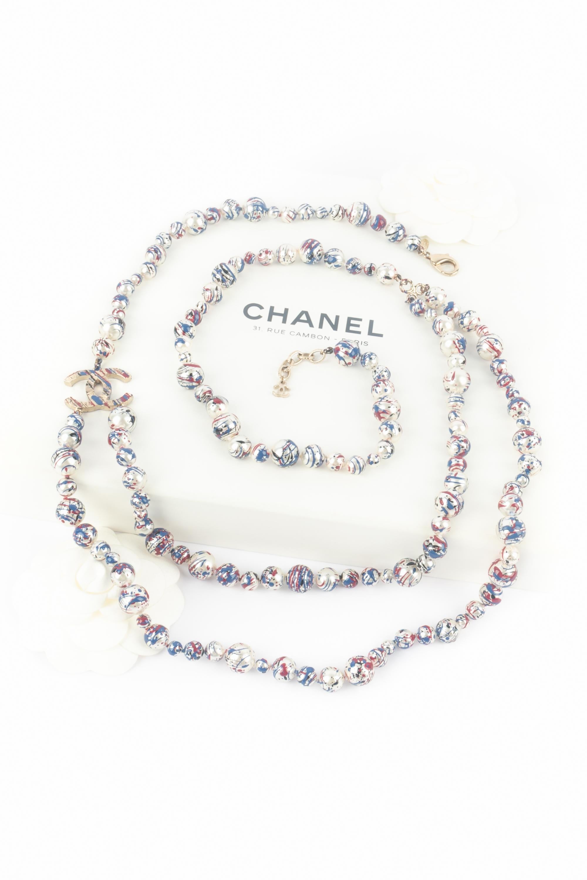 CHANEL - (Made in France) Perlenkette mit blauen und roten Farbtupfern. Eine Collection'S von 2013 unter der künstlerischen Leitung von Karl Lagerfeld.

Bedingung:
Sehr guter Zustand

Abmessungen:
Länge der kürzeren Reihe: von 100 cm bis 103