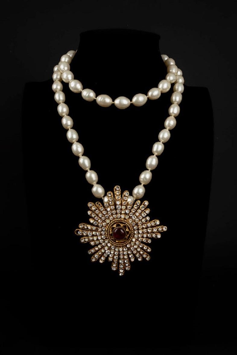Chanel - Pearl necklace and pendant brooch in metal, rhinestones and red glass paste. Collection 1984.

Additional information:
Dimensions: Length: 103 cm 
Pendant: 7 cm x 9.5 cm
Condition: Very good condition
Seller Ref number: CB62