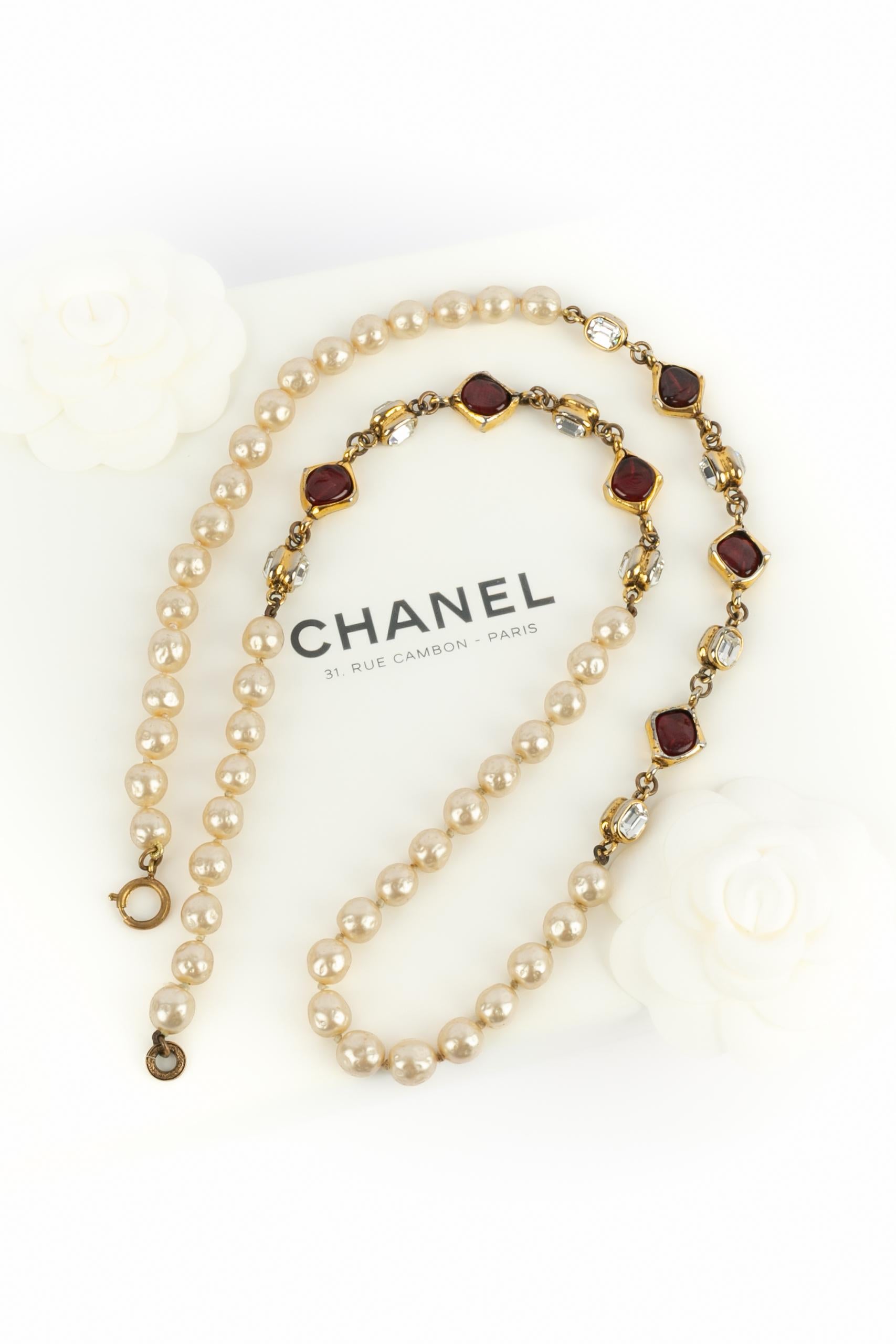 CHANEL - (Fabriqué en France) Collier de perles fantaisie avec éléments en métal doré, pâte de verre et strass. Collectional 1985.

Condit :
Très bon état.

Dimensions :
Longueur : 90 cm

SKU:CB50