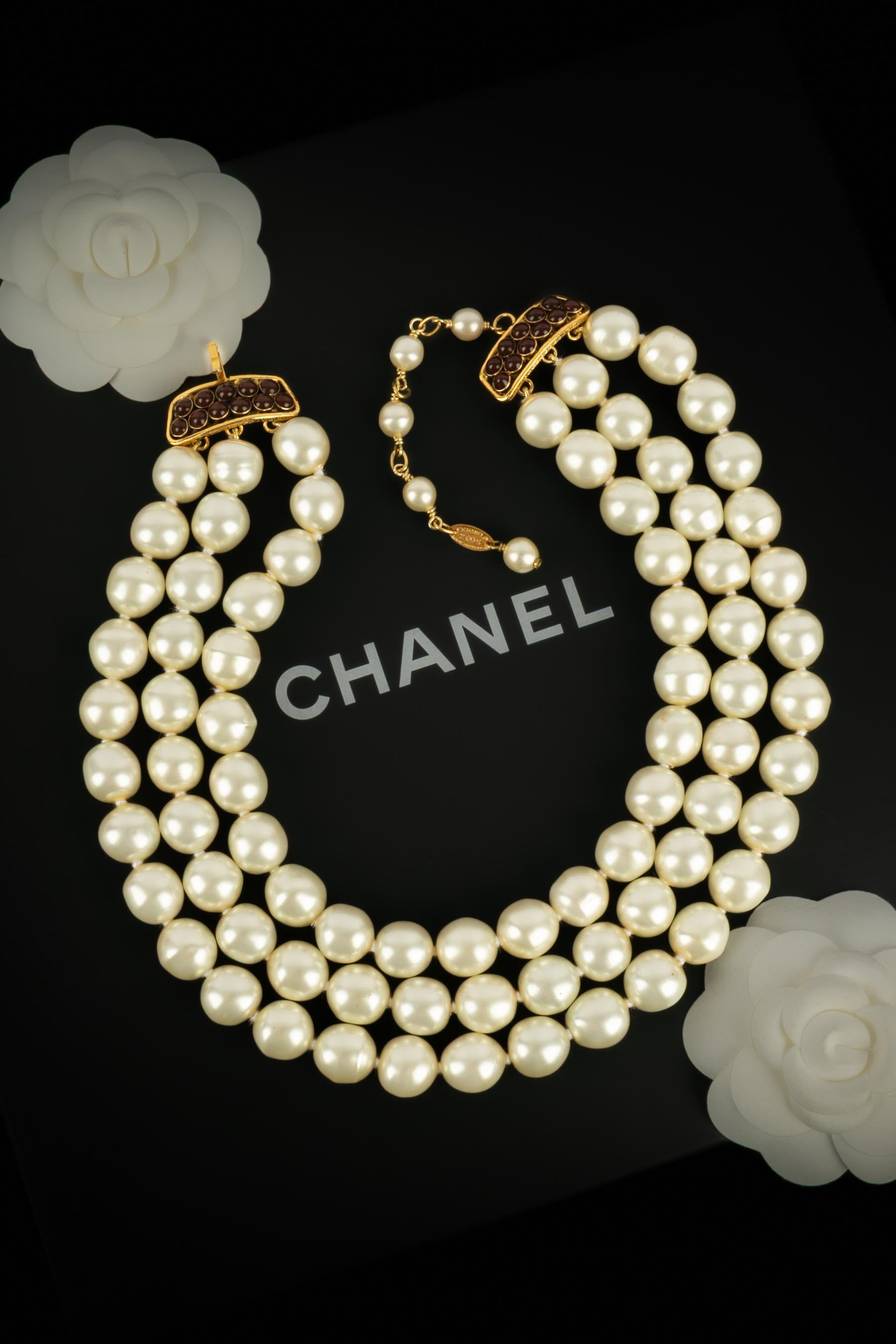 CHANEL - (Made in France) Collana di perle di costume a tre file con chiusura in metallo dorato ornata da pasta di vetro rosa. Una collezione 2cc5 sotto la direzione artistica di Karl Lagerfeld.

Condizioni:
Ottime condizioni

Dimensioni:
Lunghezza