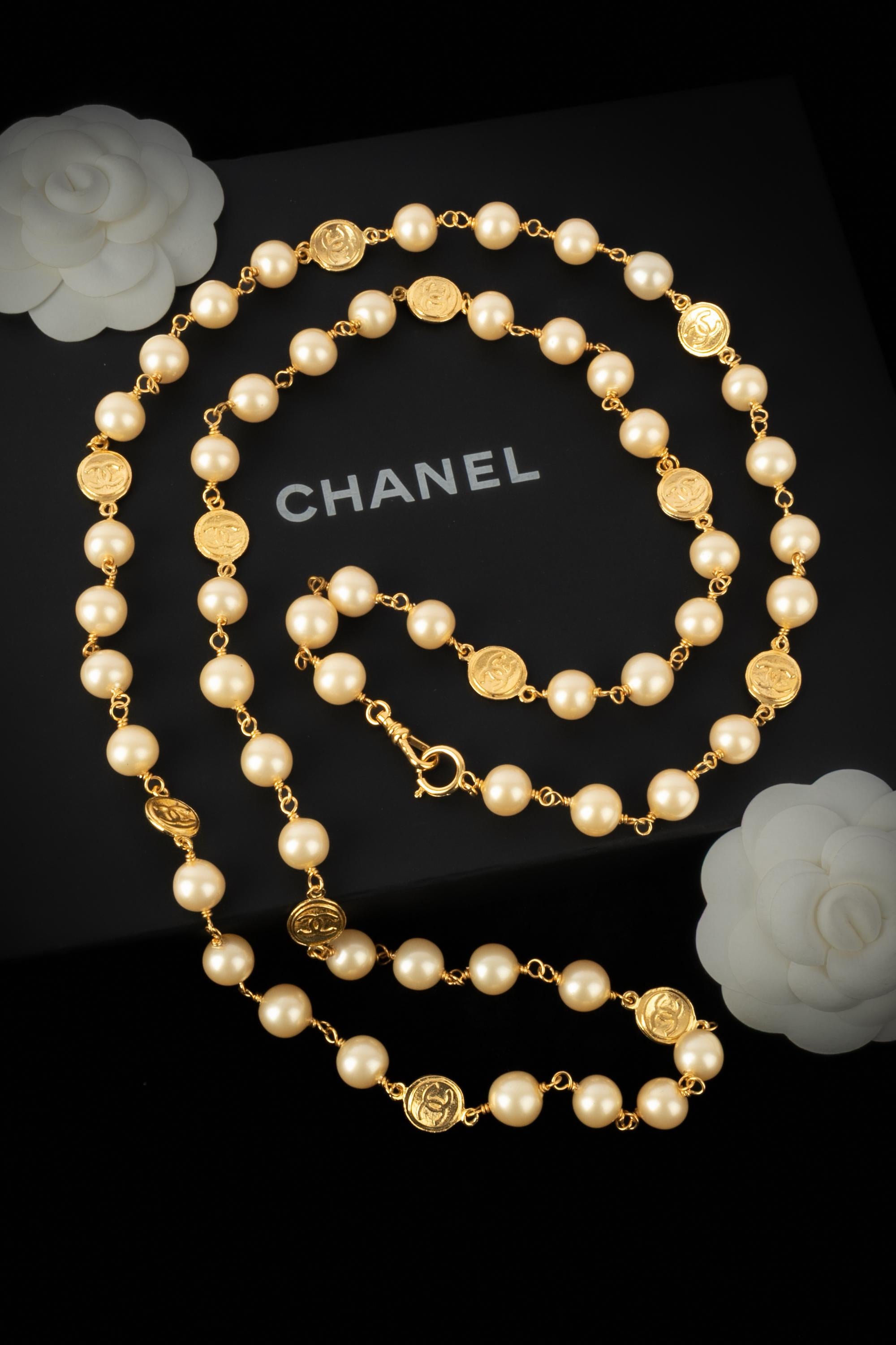 Chanel - (Made in France) Collana lunga di perle in costume con medaglioni in metallo dorato centrati da loghi cc. Gioielli degli anni '1985 sotto la direzione artistica di Karl Lagerfeld.

Condizioni:
Ottime condizioni

Dimensioni:
Lunghezza: 140