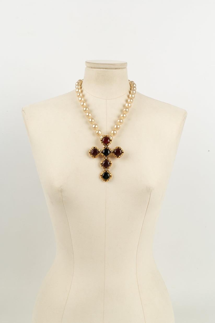 Chanel - (Made in France) Necklace made of pearly fancy pearls and a cross pendant in gold metal, Swarovski rhinestones and glass paste. 
Work of the Gripoix workshop for the Chanel house.

Additional information:
Dimensions: Length: 49 cm -