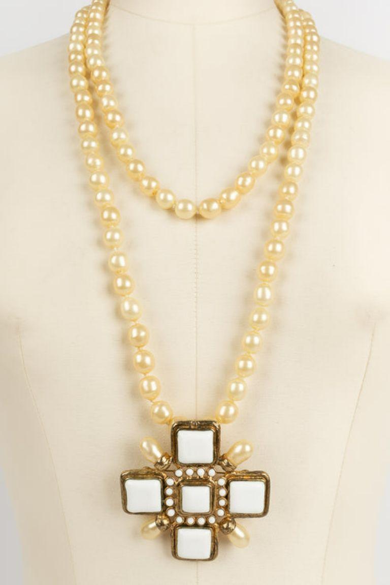 Chanel -(Made in France) Long necklace of pearly pearls and its pendant in gilded metal and glass paste. Spring-Summer 2001 collection.

Additional information: 
Dimensions: Length : 140 cm - Cross : 7 cm x 7 cm
Condition: Very good condition
Seller