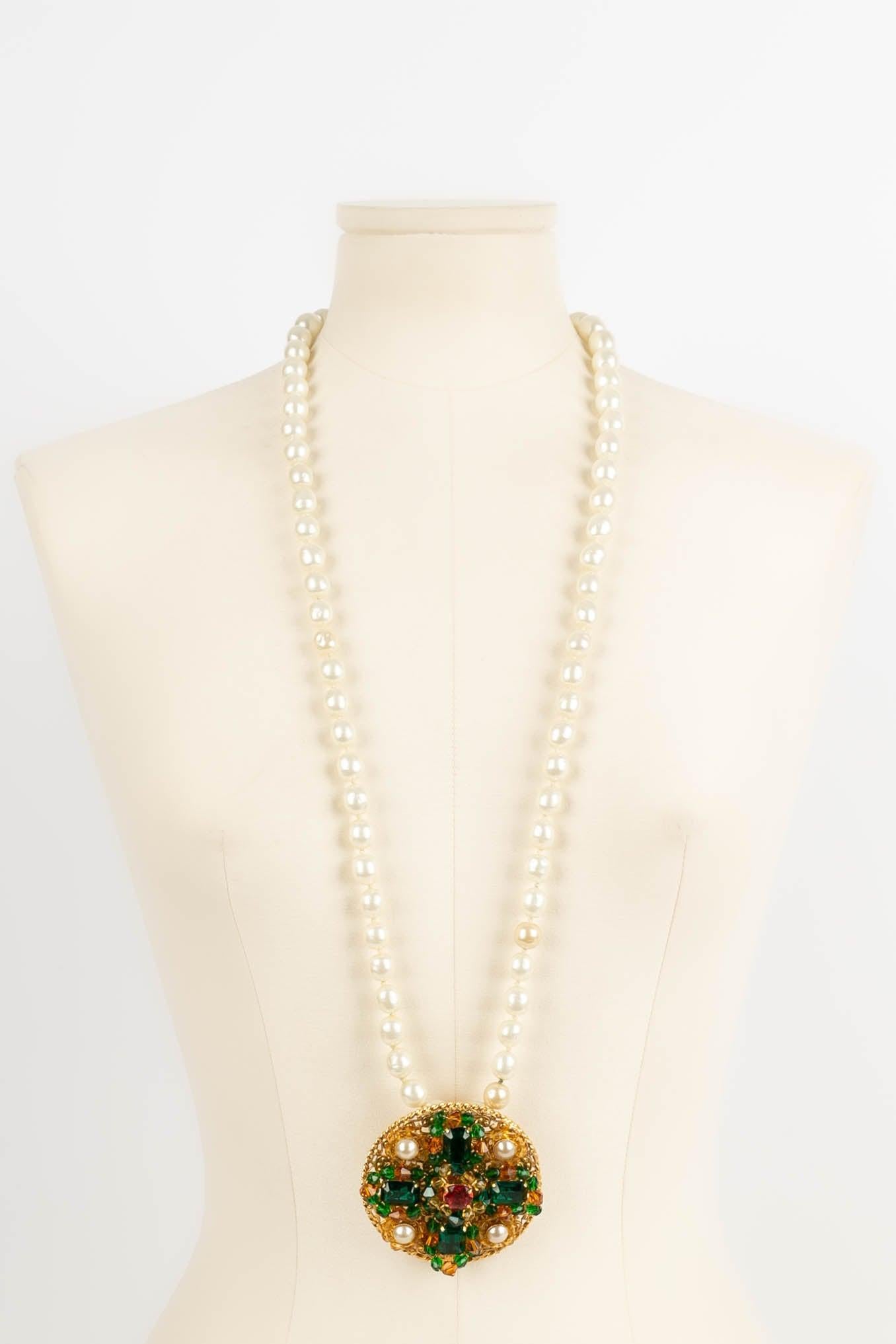 Chanel -(Made in France) Necklace composed of pearly pearls and a pendant in gilded metal, pearly cabochons and strass. Fall-Winter 1997 collection. 
Be careful, the pearly pearls have different shades.

Additional information: 
Dimensions: Length :