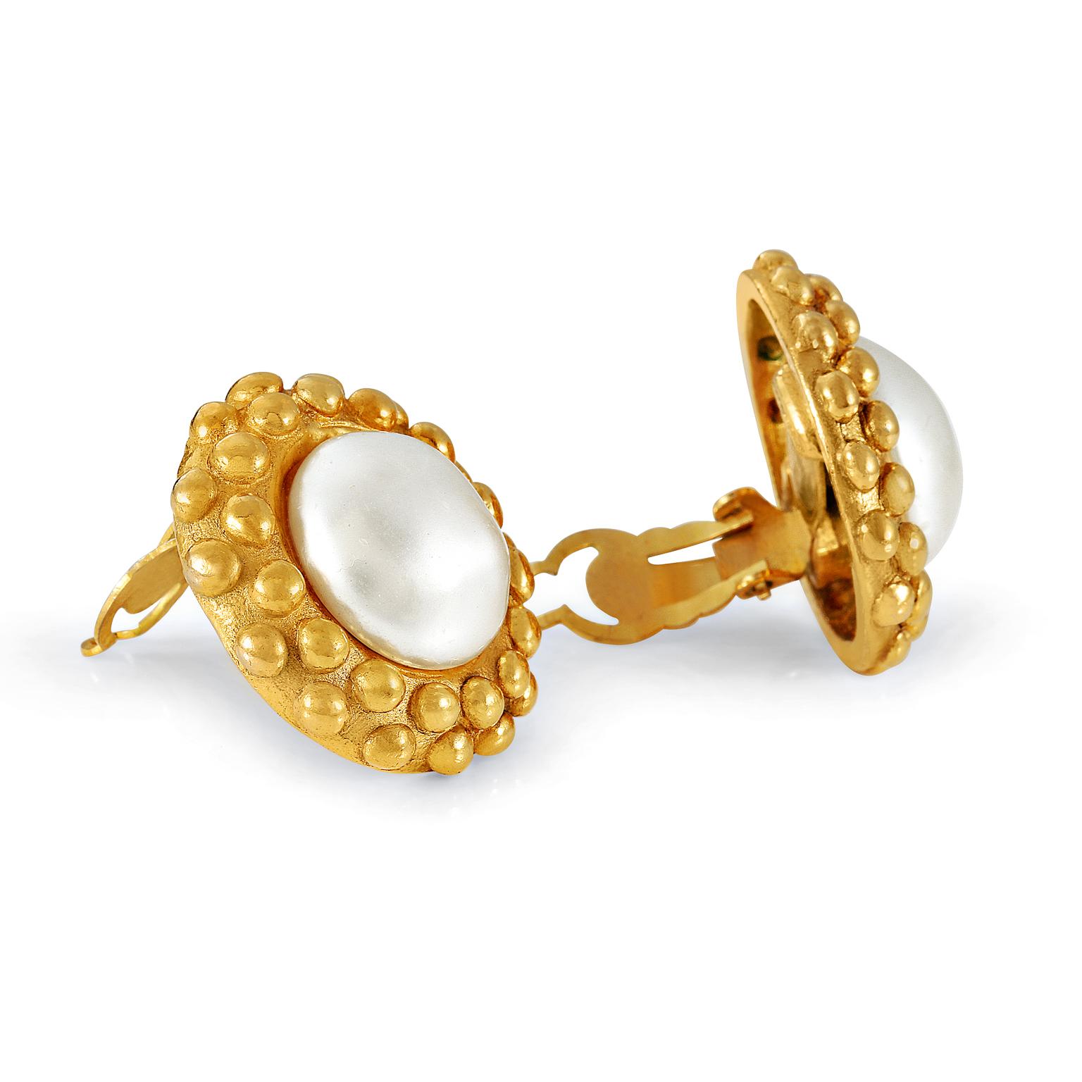 These authentic Chanel Pearl with Raised Dot Earrings are in excellent vintage condition from the 1970’s.  Large round faux pearl is surrounded by gold surround with a double row of raised polka dots.    Clip on closure. Made in France.

