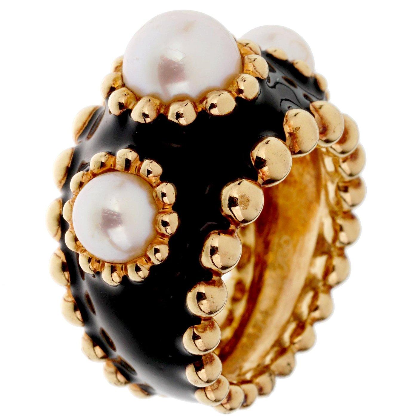 A lovely authentic Chanel ring circa 1990s showcasing 3 pearls each with a beaded row encased with black enamel in 18k yellow gold. The ring measures a size 5 3/4

