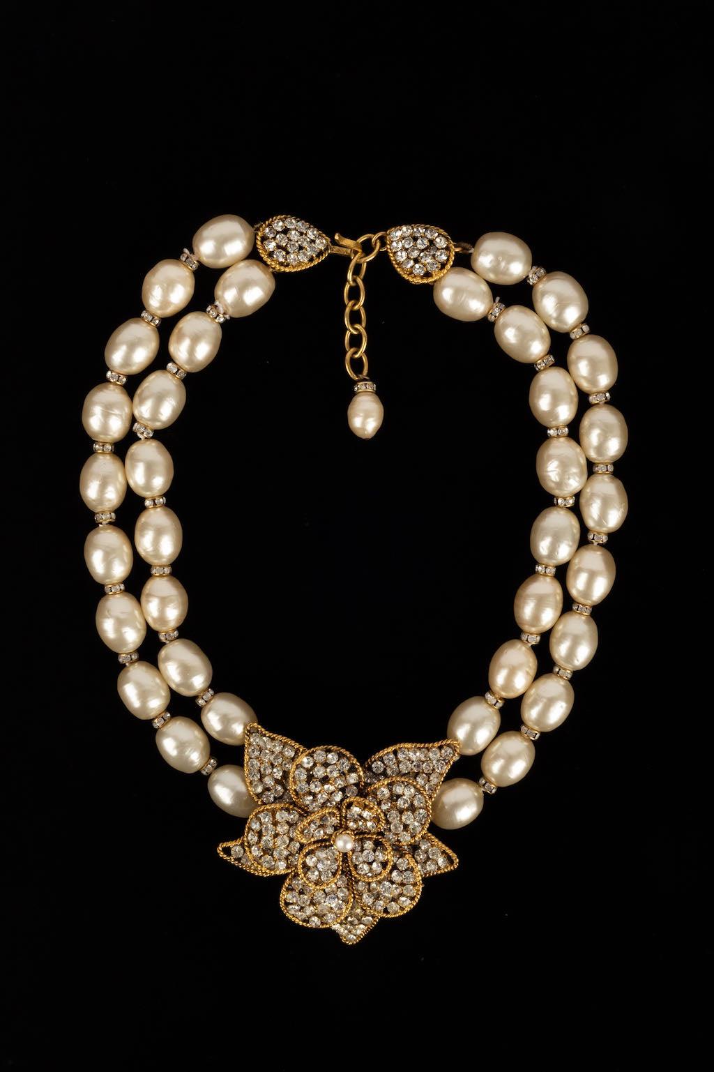 Chanel -(Made in France) Necklace with two rows of pearly pearls and rhinestones holding a golden metal flower paved with rhinestones.

Additional information: 
Dimensions: Length: 41 cm - Height: 6 cm
Condition: Very good condition
Seller Ref