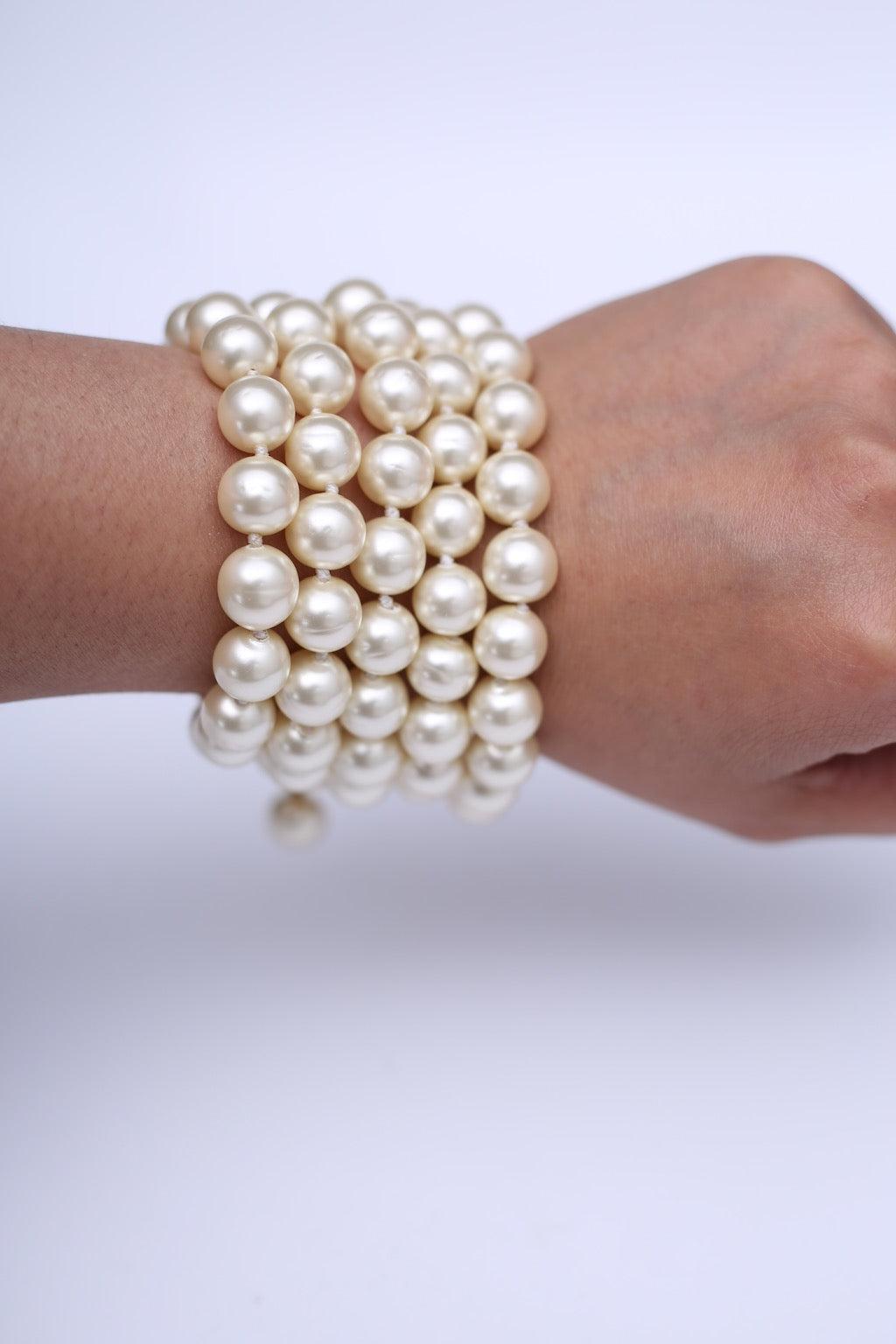 Chanel - (Made in France) Armband, bestehend aus fünf Strängen mit geknüpften Perlen. Sie wird mit einem goldenen Metallverschluss mit einer kleinen Kette geschlossen. Auf einem Schild signiert. 2cc3 Collection'S.

Zusätzliche