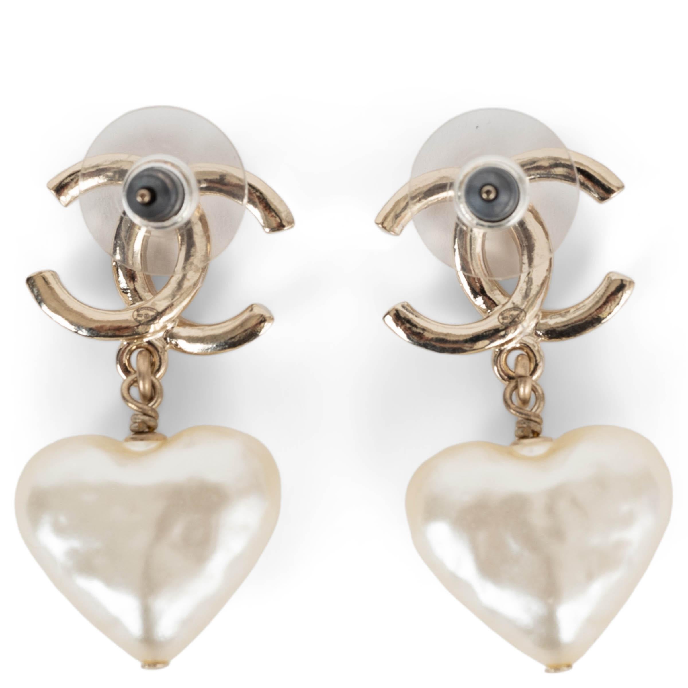This 100% authentic Chanel CC earrings in beige gold-tone metal exude timeless elegance with a romantic touch. Featuring pearly white heart-shaped resin pearls with a delicate hammered texture, they dangle gracefully from the iconic CC logo. A