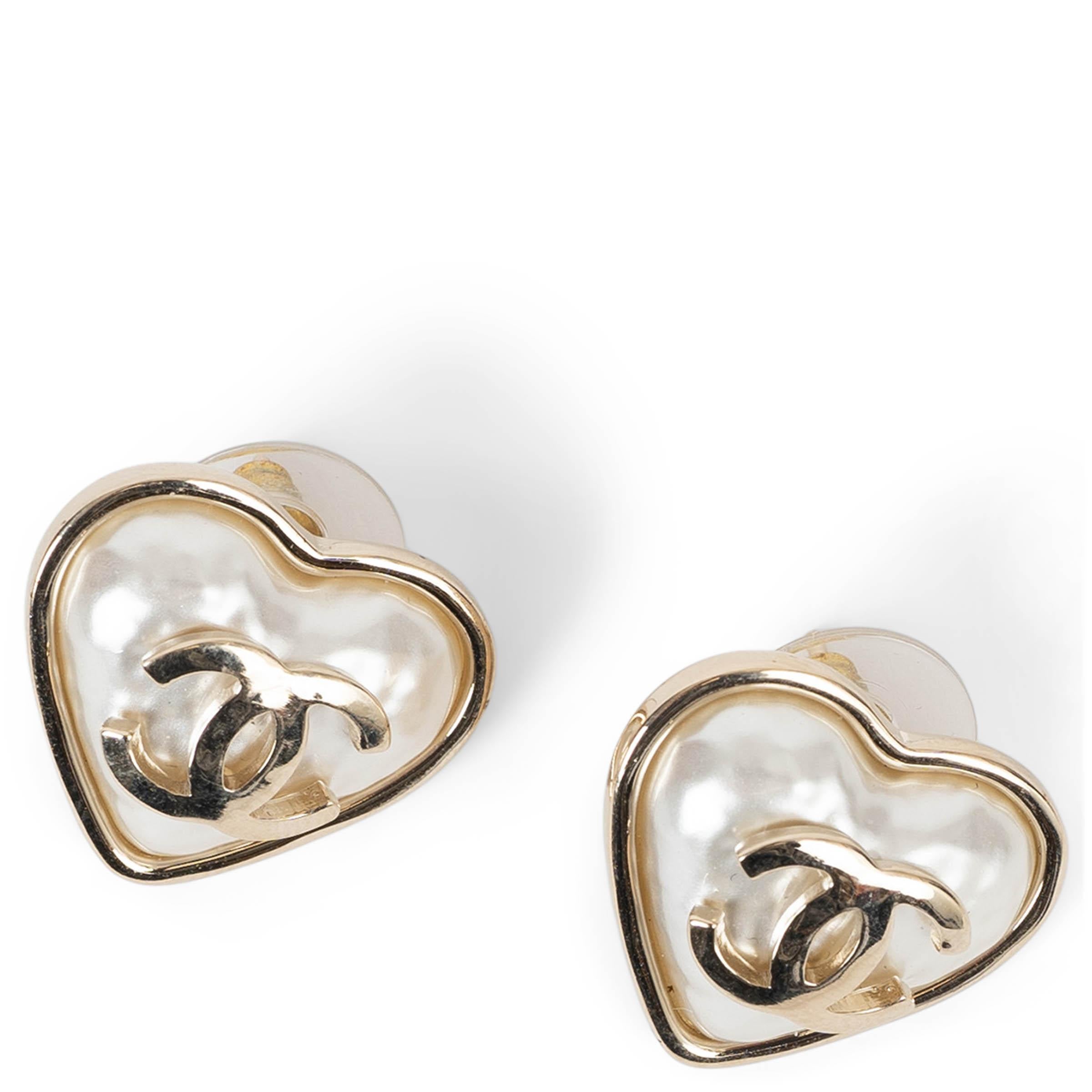 Questi orecchini a cuore Chanel 100% autentici in metallo dorato beige emanano un'eleganza classica con un tocco moderno. Whiting in resina martellata bianca perlata, sono arricchiti da una CC dorata al centro per un tocco di classe. Un accessorio