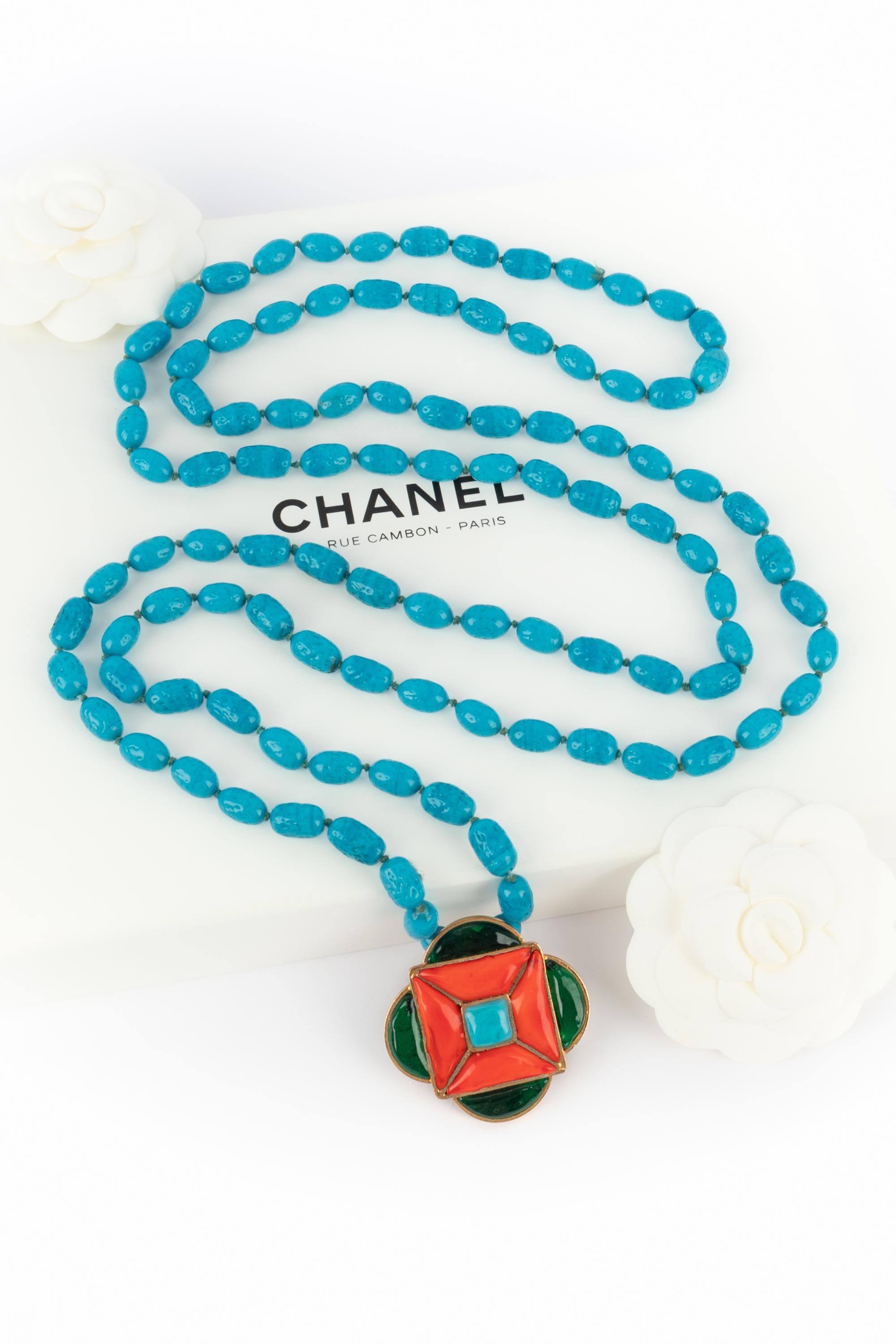 CHANEL - (Made in France) Turquoise-color glass pearl necklace with a golden metal pendant with orange and green glass paste. 2cc8 Collection under the artistic direction of Karl Lagerfeld.

Condition:
Very good condition

Dimensions:
Length: 150 cm