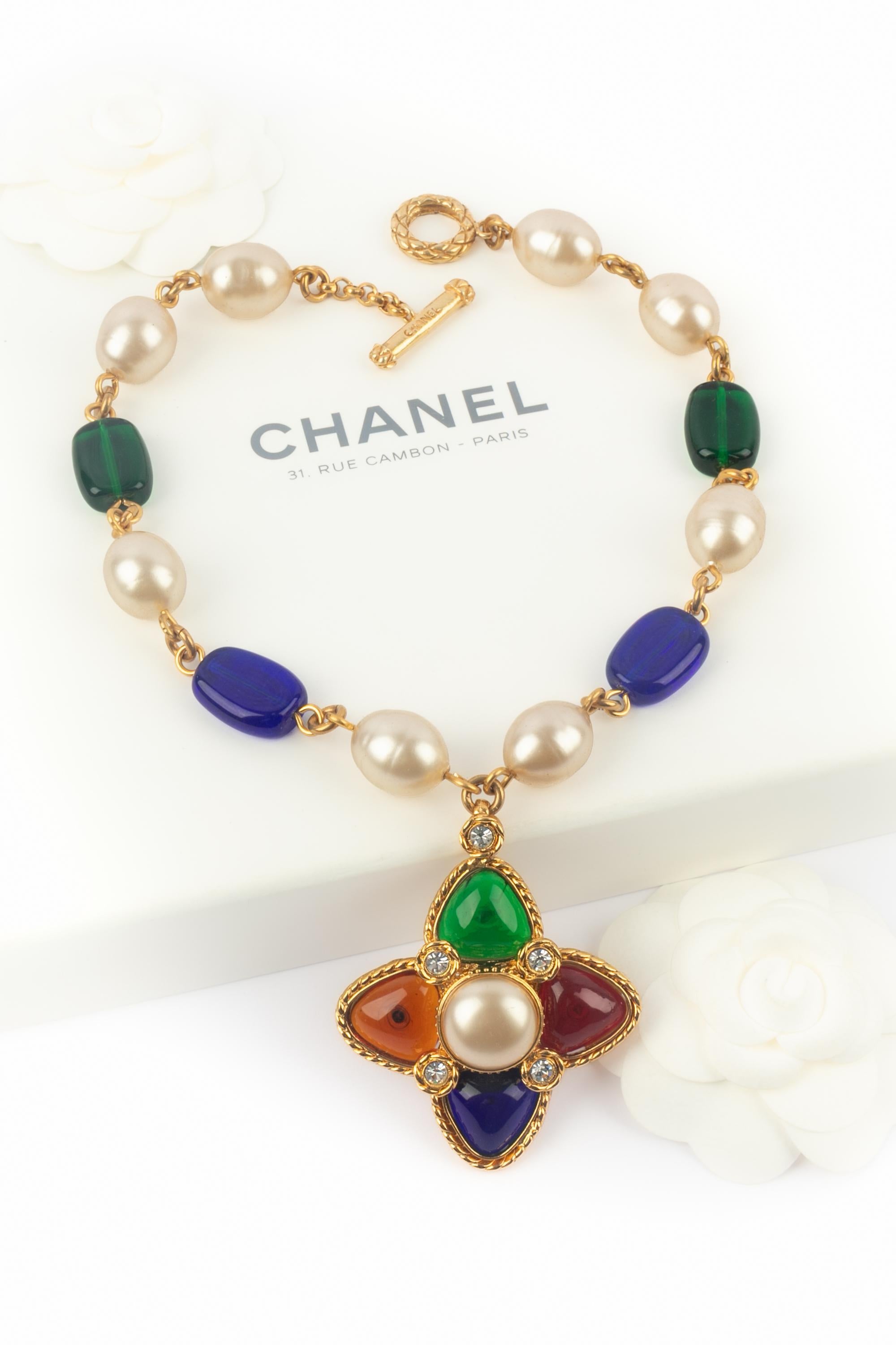 Chanel - (Made in France) Collana con ciondolo in metallo dorato e perle in pasta di vetro. Una collezione 2cc6 dei primi anni '90 sotto la direzione artistica di Karl Lagerfeld.

Condizioni:
Ottime condizioni

Dimensioni:
Lunghezza: 45 cm -