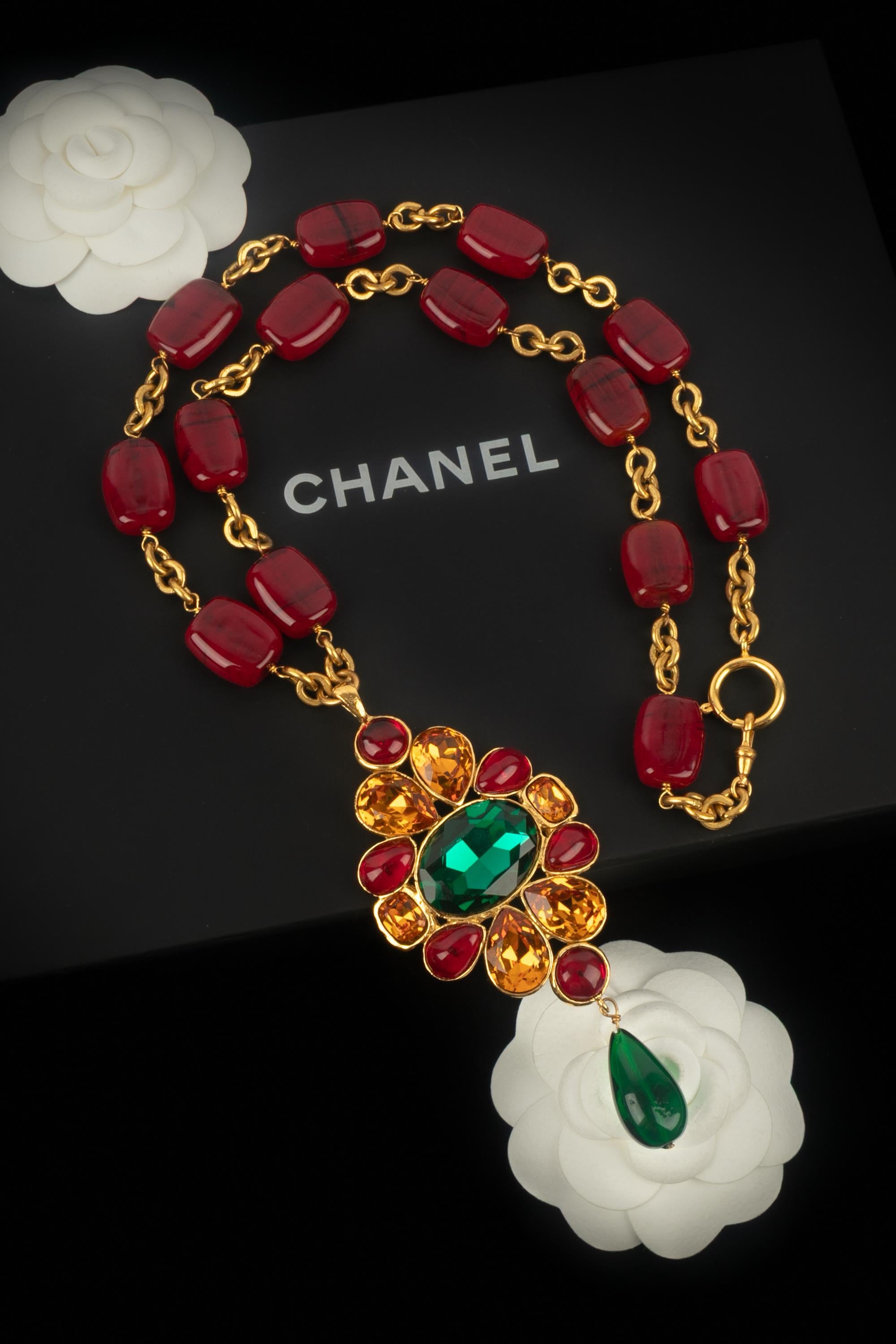 Chanel - (Made in France) Collana lunga in metallo dorato con perle di vetro rosse e un pendente con strass. Una collezione 2cc6 dei primi anni '90 sotto la direzione artistica di Karl Lagerfeld.

Condizioni:
Ottime