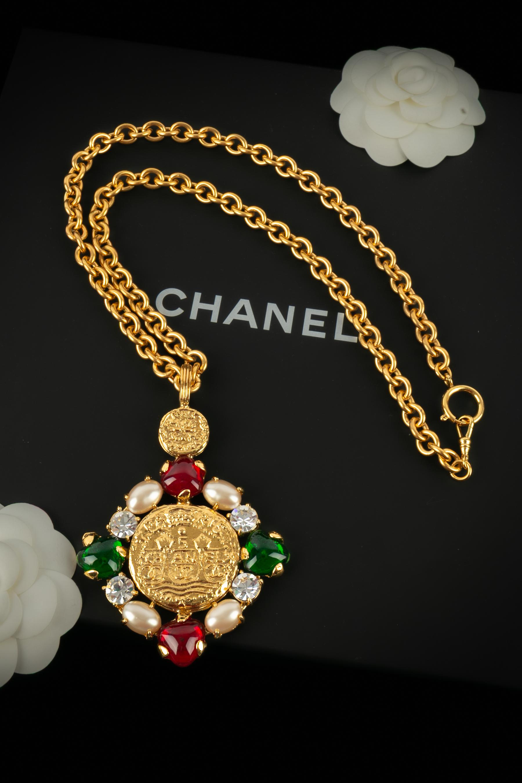 Chanel - (Made in France) Lunga collana a catena in metallo dorato, con ciondolo ornato da cabochon in pasta di vetro e strass. Collezione Autunno-Inverno 1993 sotto la direzione artistica di Karl Lagerfeld.

Condizioni:
Ottime