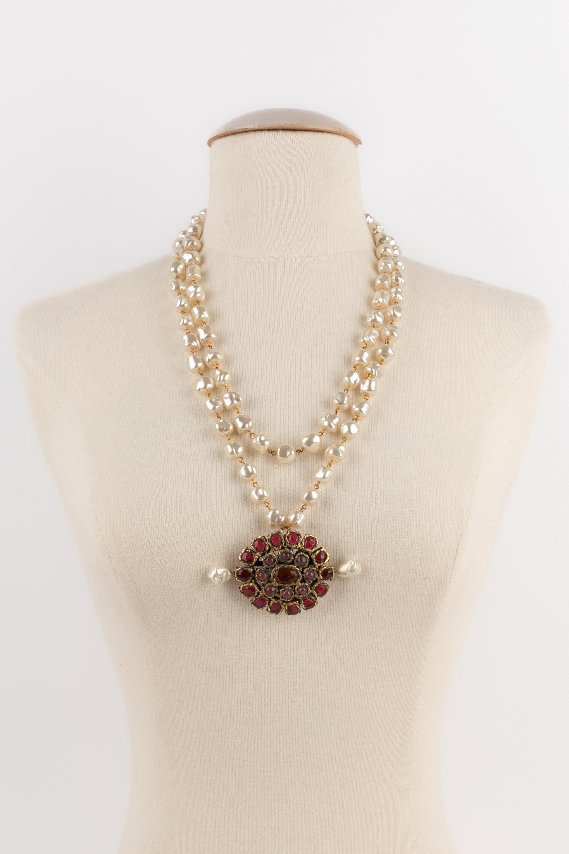 Chanel - (Made in France) Baroque costume pearl necklace with a golden metal pendant and red glass paste. A 1984 Collection.

Additional information:
Condition: Very good condition
Dimensions: Length: 120 cm - Pendant: 9 cm x 5 cm
Period: 20th