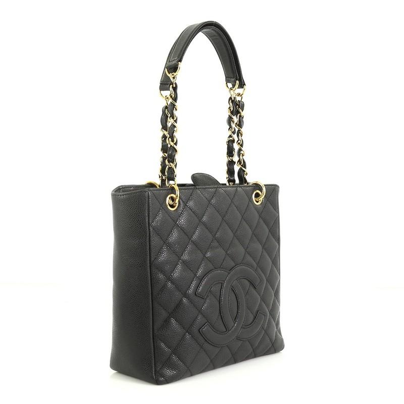 This Chanel Petite Shopping Tote Quilted Caviar, crafted from black quilted caviar leather, features a stitched CC logo, dual woven-in leather chain straps with leather pads, exterior back slip pocket, and gold-tone hardware. Its magnetic snap
