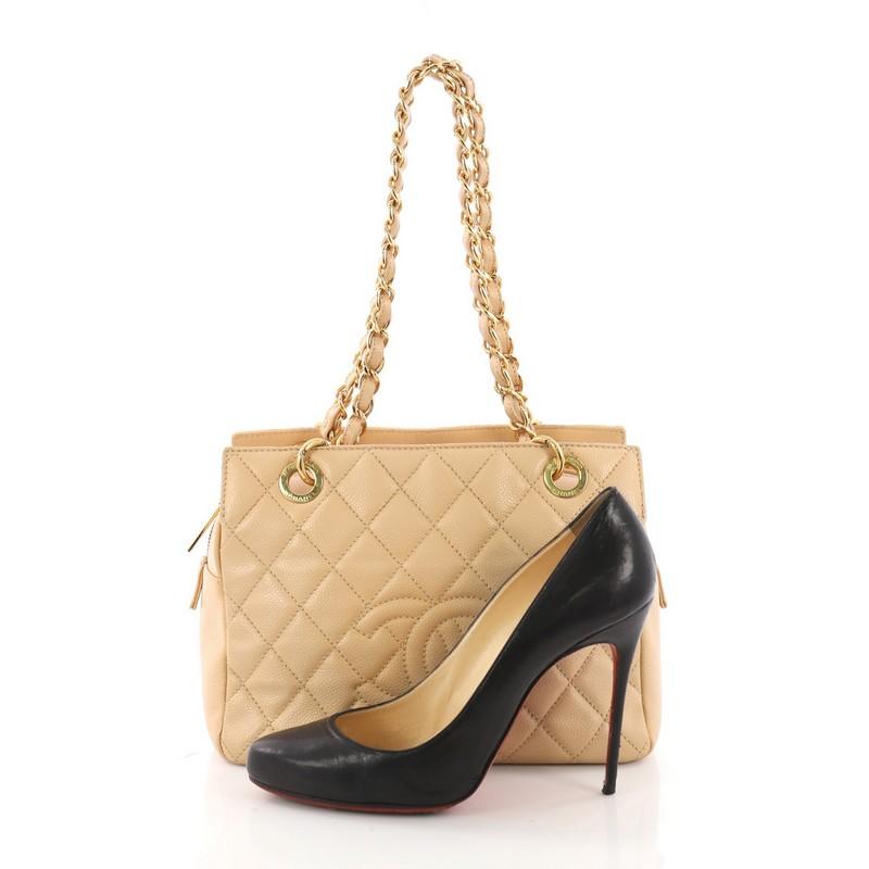 This Chanel Petite Timeless Tote Quilted Caviar, crafted in beige quilted caviar leather, features dual woven in leather chain link strap, interlocking CC logo and gold-tone hardware. Its zip closure opens to a beige fabric interior with side zip