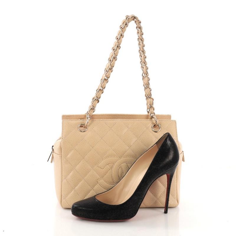 This Chanel Petite Timeless Tote Quilted Caviar, crafted in beige quilted caviar leather, features dual woven in leather chain link straps, interlocking CC logo, and gold-tone hardware. Its zip closure opens to a beige fabric interior with side zip