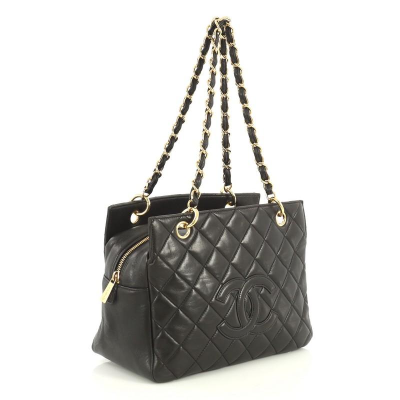 This Chanel Petite Timeless Tote Quilted Lambskin, crafted in black quilted lambskin leather, features dual woven-in leather chain link straps, interlocking CC logo, and gold-tone hardware. Its zip closure opens to a black fabric interior with side