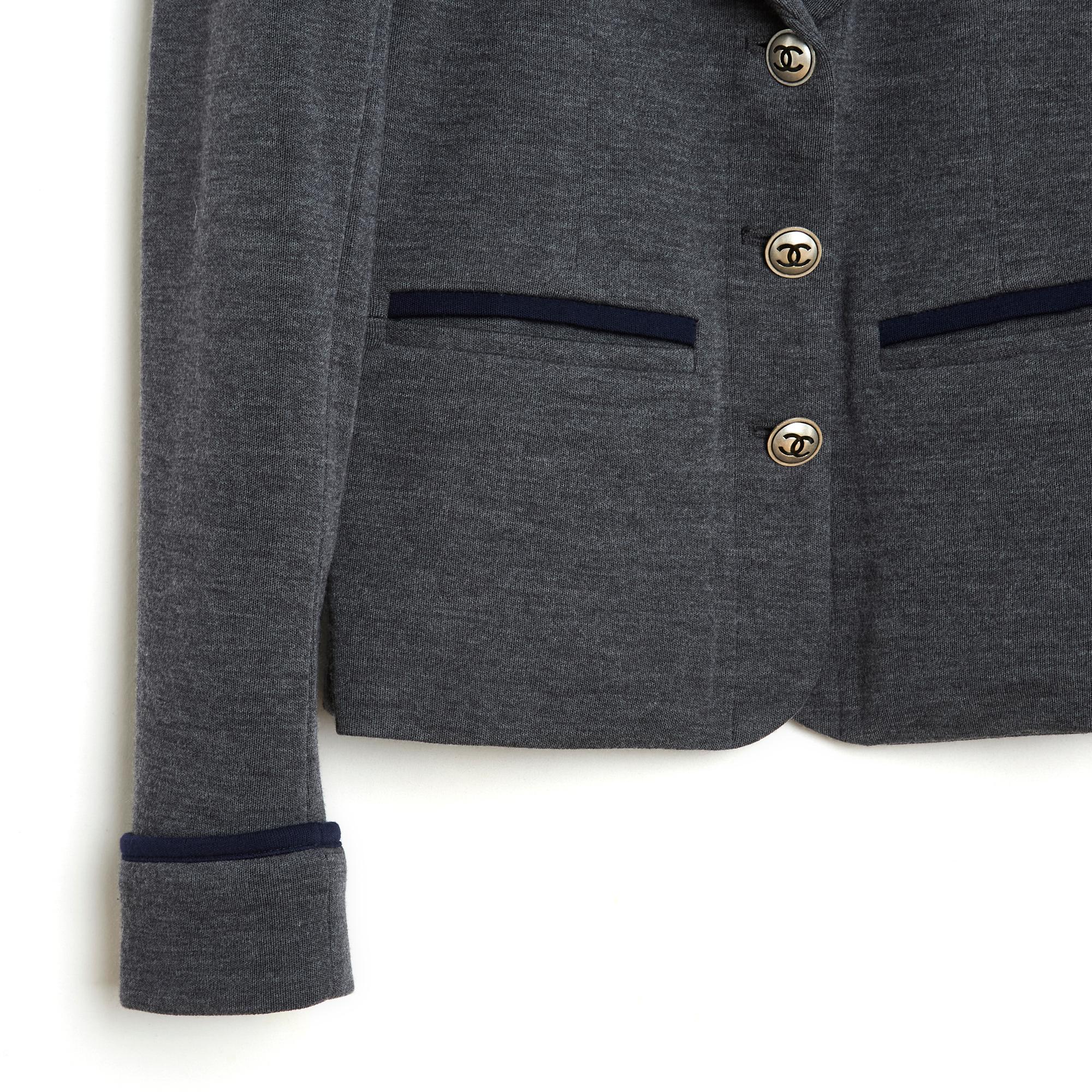 Chanel jacket from the Métiers d'Art Shanghai or Pre Fall 2010 collection, blazer style in grey wool jersey with navy blue piping, shawl collar closed by 3 CC buttons, 2 slit pockets on the hips and a chest pocket, long sleeves with piping lapels,