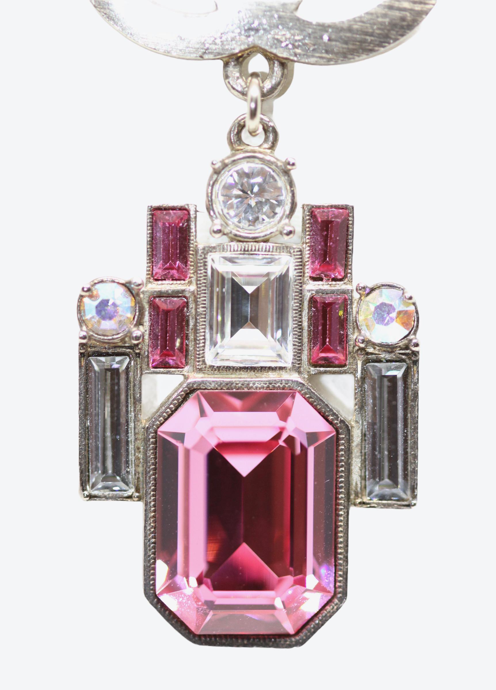 This pre-owned stunning necklace from the house of Chanel is part of the 2006 Spring / Summer collection. 
It is crafted from light gold-tone metal. Its fine chain holds a CC Logo and pink and white square-cut crystals pendant. It is finished with a