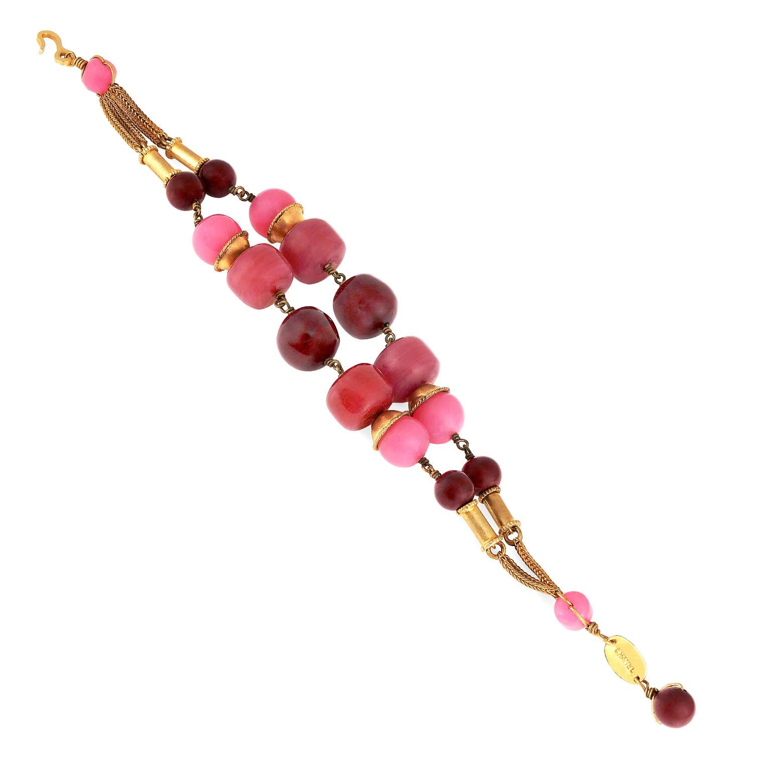 This authentic Chanel Pink Gripoix Double Strand Bracelet is in very good condition. 
 Burgundy and pink chunky Gripoix beads with gold accents.  Perfect statement piece for everything from summer dresses to a tee shirt and jeans.
