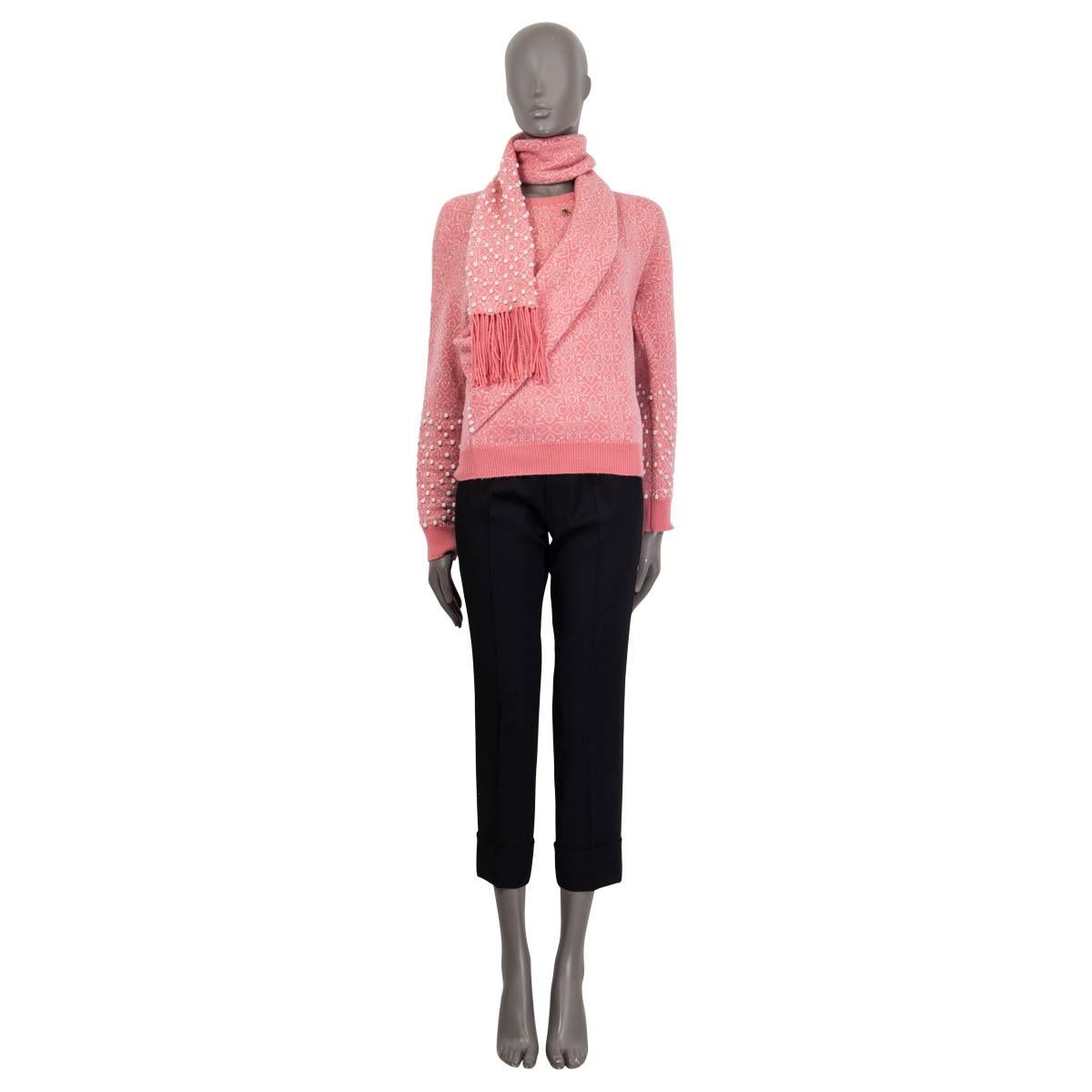 100% authentic Chanel Bombay Metier 2012 fringed scarf sweater in pink and off-white cashmere (99%) and nylon (1%). Features a small flower brooch on the front and small pompons at the sleeves and the scarf. Unlined. Has been worn and is in