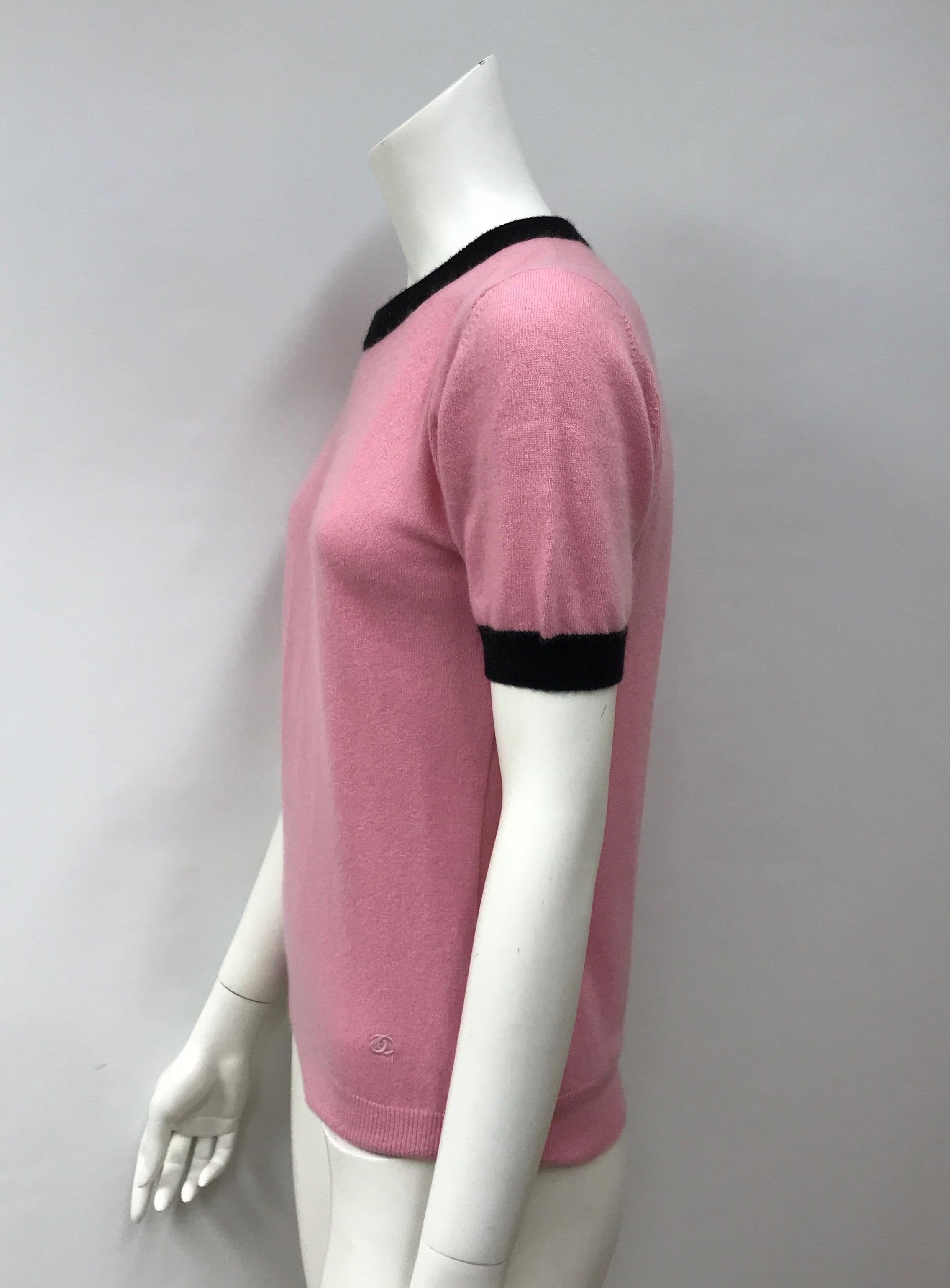 Chanel Pink Cashmere Top w/ Black Trim-44. This adorable Chanel Top is in excellent condition. There is no sign of use, minimal shaving needed. It is made of 100% cashmere in a pink color. There is black cashmere trim on the sleeves and neckline. It