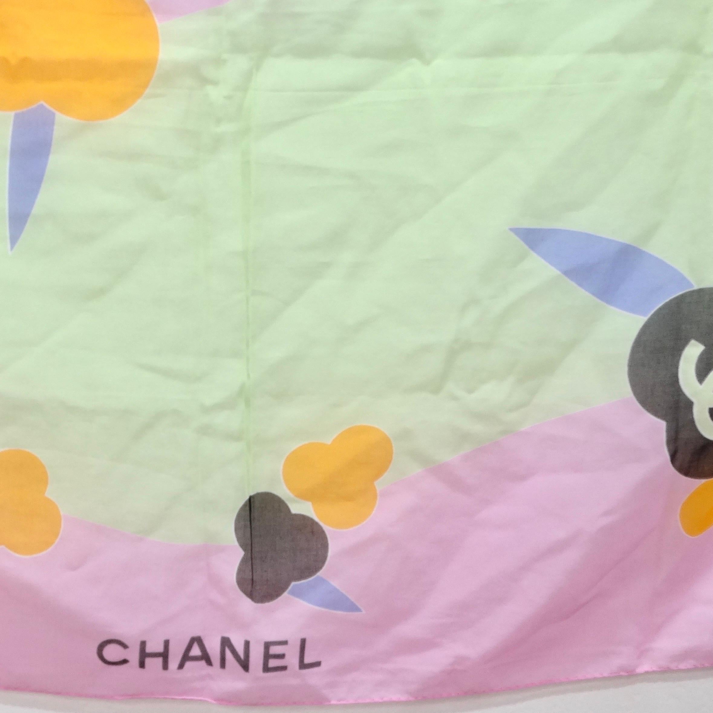 Indulge in the epitome of chic sophistication with this Chanel pink scarf floral scarf, a timeless accessory that exudes elegance. This exquisite scarf features black Chanel logos and the signature interlocking 'C' motif, beautifully complemented by