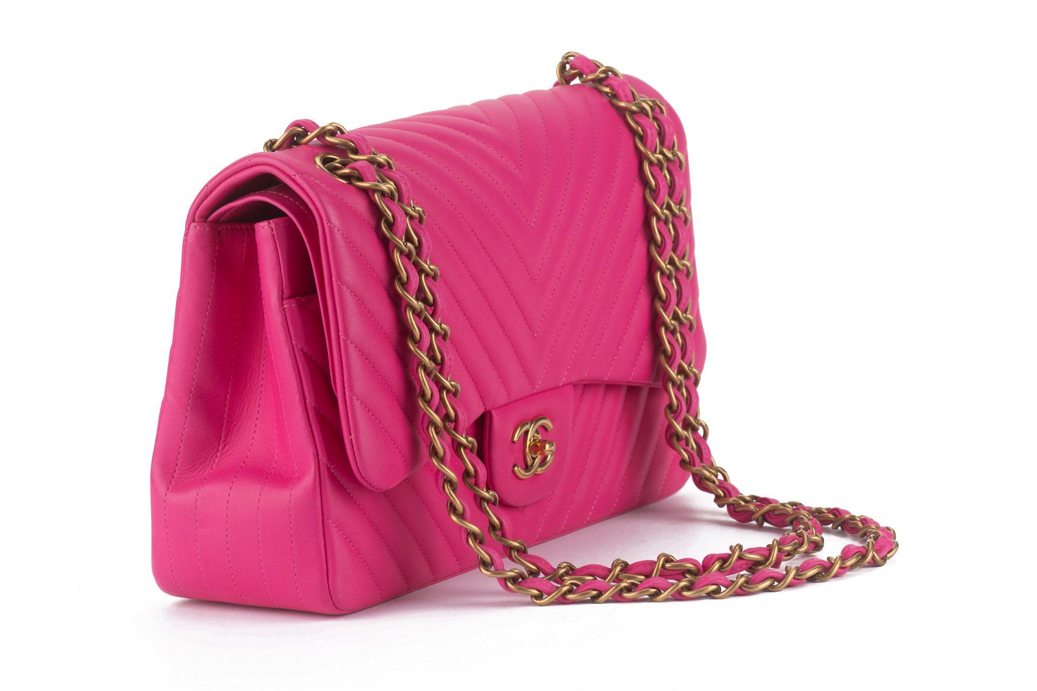 Ce sac Chanel Pink Chevron Quilted Lambskin Leather Classic Medium Double Flap Bag se compose de cuir d'agneau matelassé, d'une fermeture CC à verrou tournant et d'un intérieur à double rabat. La chaîne réglable en cuir peut être portée à l'épaule