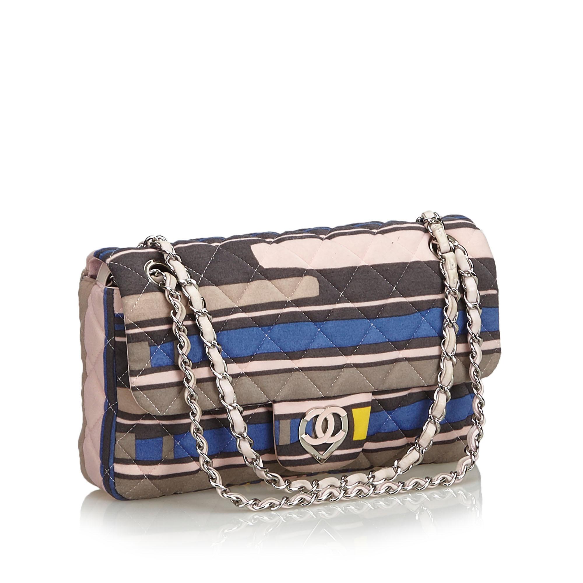 The CC Heart Medium Flap bag features a printed cotton body, a back exterior slip pocket, leather woven chain handles, a top flap with a magnetic closure, and interior zip and slip pockets. It carries as AB condition rating.

Inclusions: 
Dust