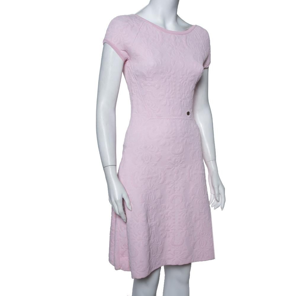 This dress will add an understated appeal to your off-duty looks. Designed in a pretty silhouette with a drop waist, this Chanel dress is cut from embossed jacquard fabric. It flaunts a subtle pink hue and is complete with a zip fastening. Team this