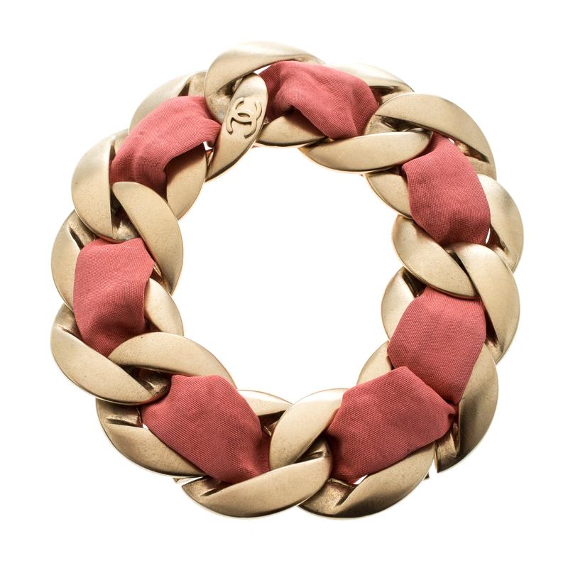 Well-made accessories have the power to enhance any outfit. This bracelet by Chanel is so pretty, you'll love having it around your wrist. The exquisite creation is crafted from gold-tone metal and styled to resemble a chain, while a band of pink