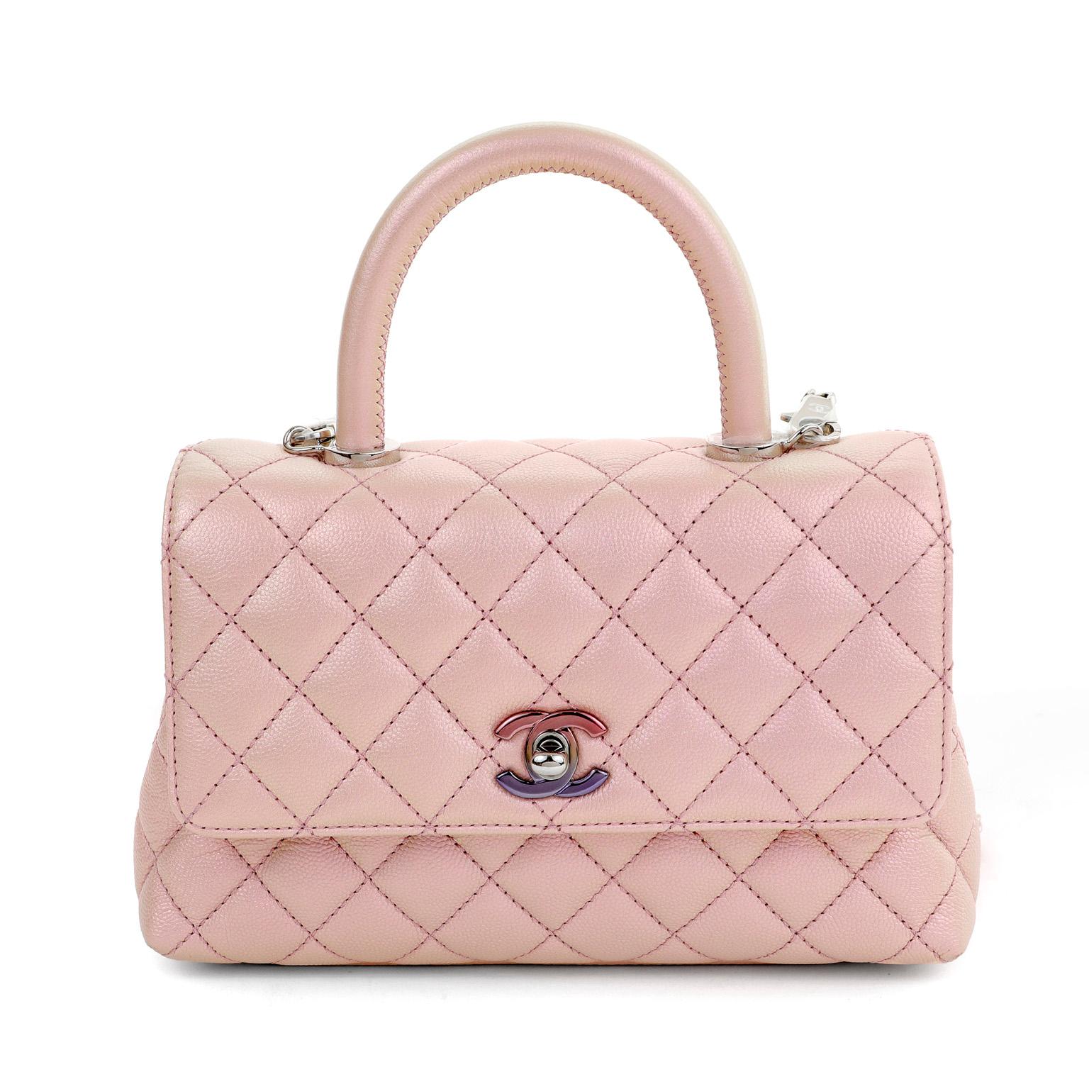 This authentic Chanel Iridescent Caviar Small Coco Handle Flap Bag is in pristine condition.  Elegant and sophisticated, the Coco handle is an exquisite departure from the Classic Flap silhouette. 
Pink iridescent caviar leather is textured and