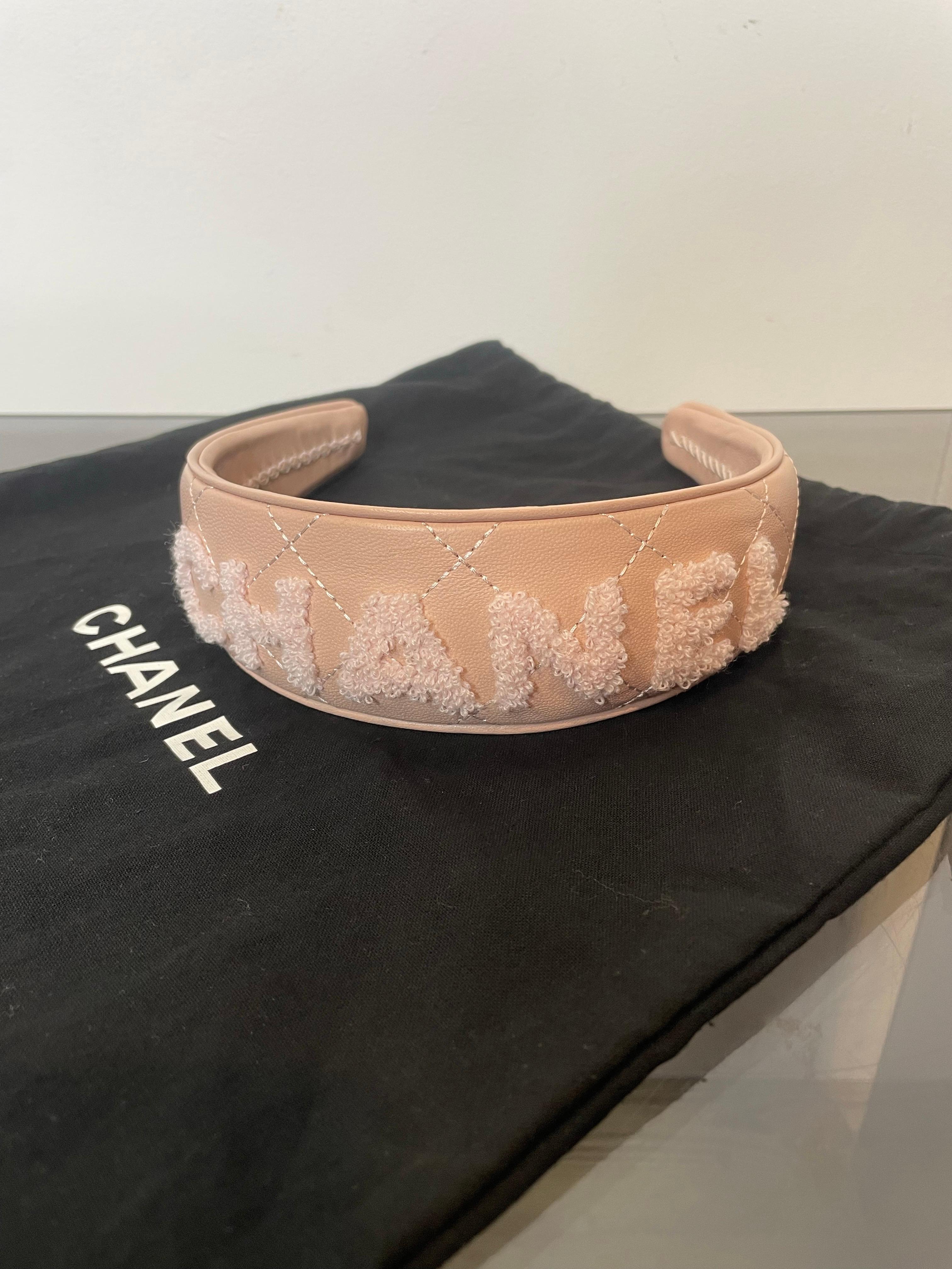 Fascia in pelle rosa con logo Chanel ricamato. Presenta un piccolo segno, come mostrato nella foto, ma non è significativo.