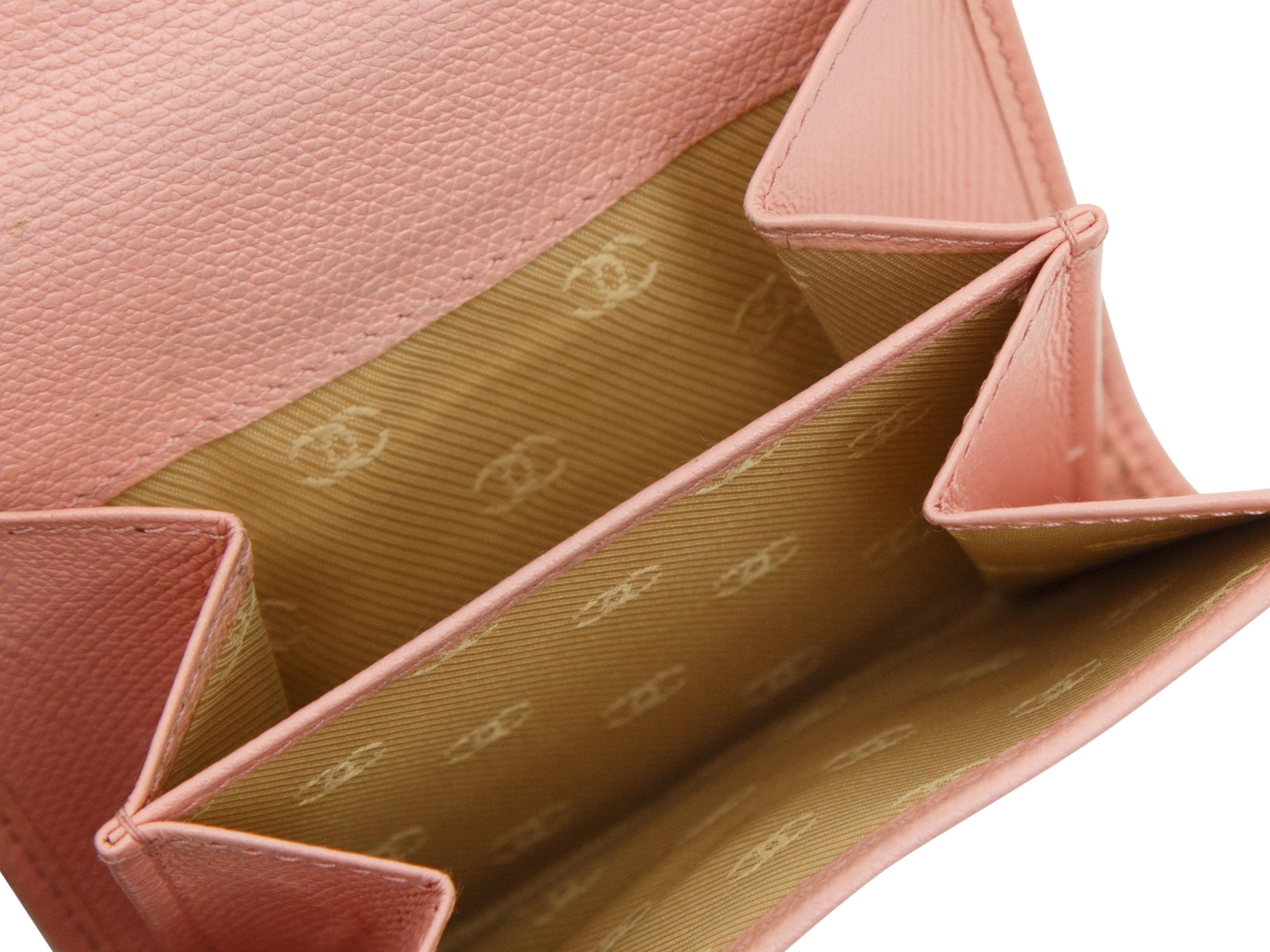 Product details:  Pink leather Sevruga compact wallet by Chanel.  Front flap with snap closure.  Multiple inner credit card slots and bill compartment.  Back flap coin pouch with snap closure.  Goldtone hardware.  4