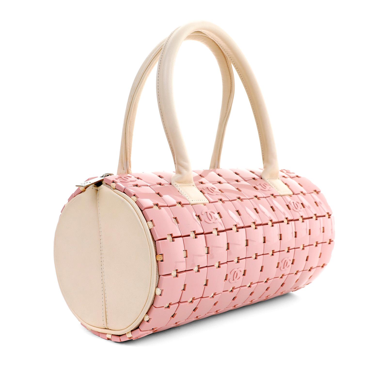 This authentic Chanel Pink Lucite Puzzle Mini Barrel Bag is a rare find in pristine condition.  Light pink Lucite CC logo puzzle pieces cover the exterior of a duffel shaped satchel.  Zippered top accesses the leather interior.  Double beige leather