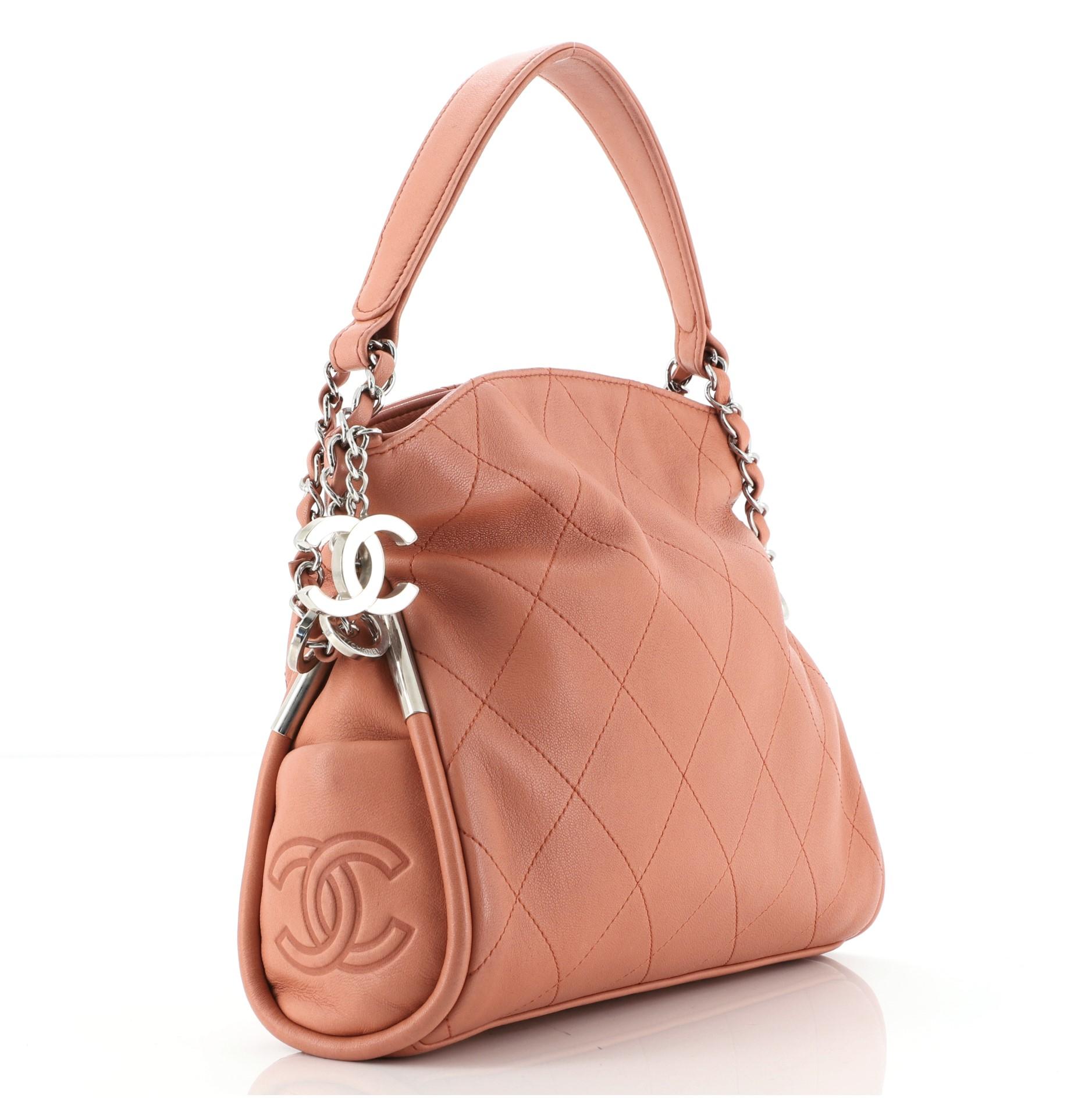 Chanel Pink Quilted Leather Ultimate Small Soft Hobo Bag features silver-tone hardware, single chain-link and leather shoulder strap with shoulder guard, dual slip pockets with embossed CC accent at sides, tonal logo jacquard lining, single zip