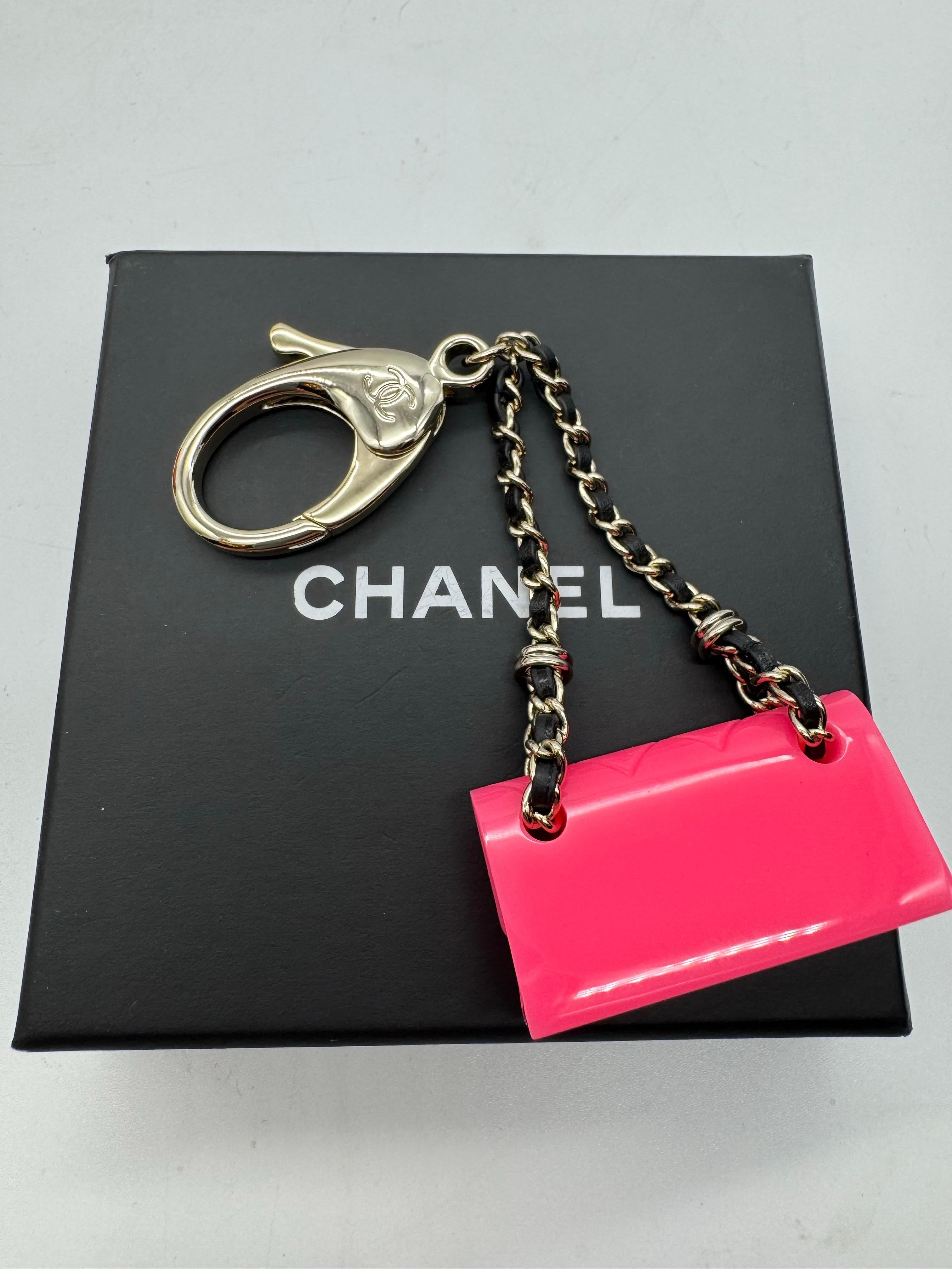 This is an authentic CHANEL Calfskin Metal Resin CC Quilted Flap Bag Charm in Gold, Black and Pink. This small charm keychain bag charm is crafted of pink resin with a calfskin leather threaded gold chain strap