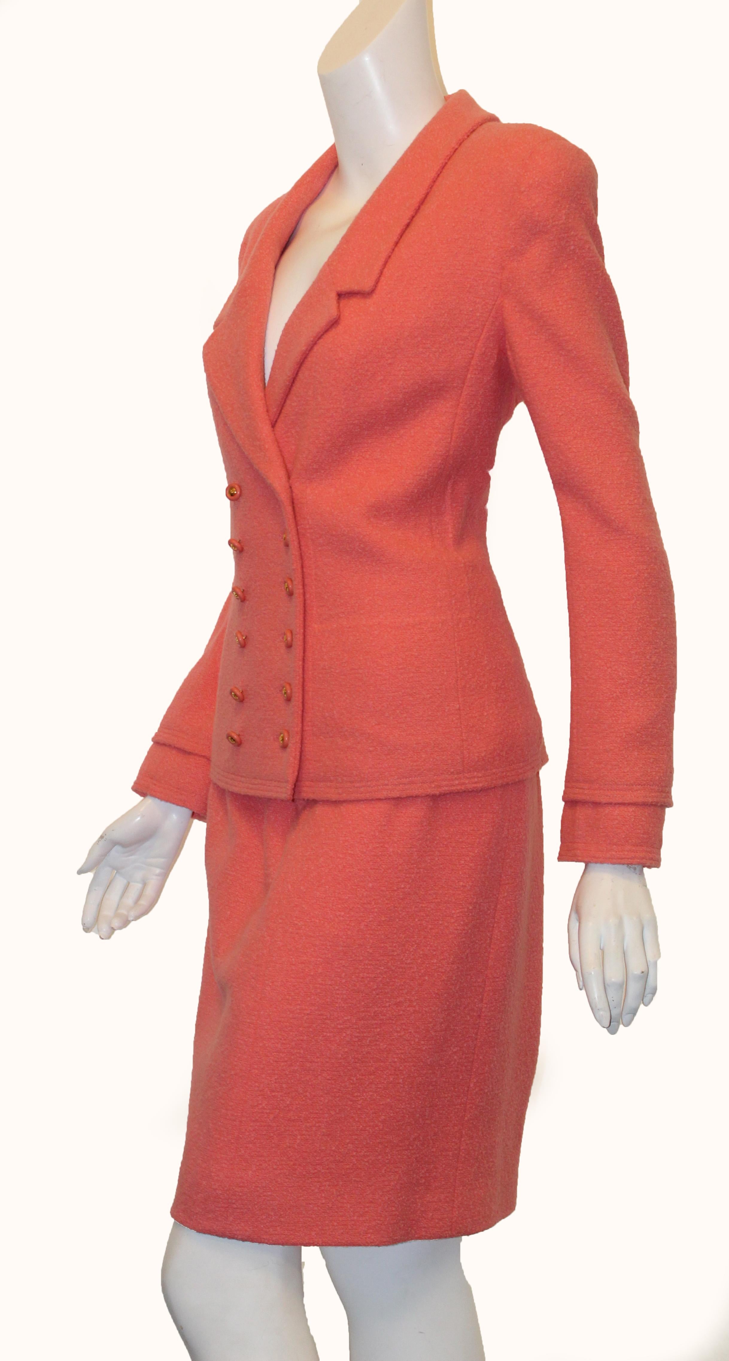 Chanel pink salmon wool and mohair double breasted suit includes 12 CC buttons at front for closure.  This multi panel suit with notch collar and long sleeve with turn down cuff is in excellent condition.  The skirt has a 3 buttoned vent at back and