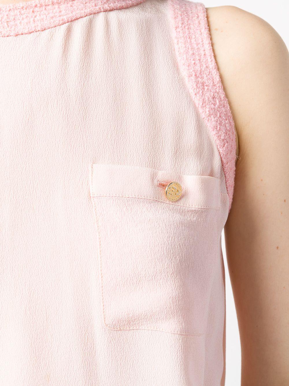 Expertly crafted in France from pure powder pink silk, this classic, pre-owned blouse perpetuates Chanel's finesse with a sleeveless design, a fluid style and bold, textured tweed framing the round-neck and underarms. The straight hem and two chest